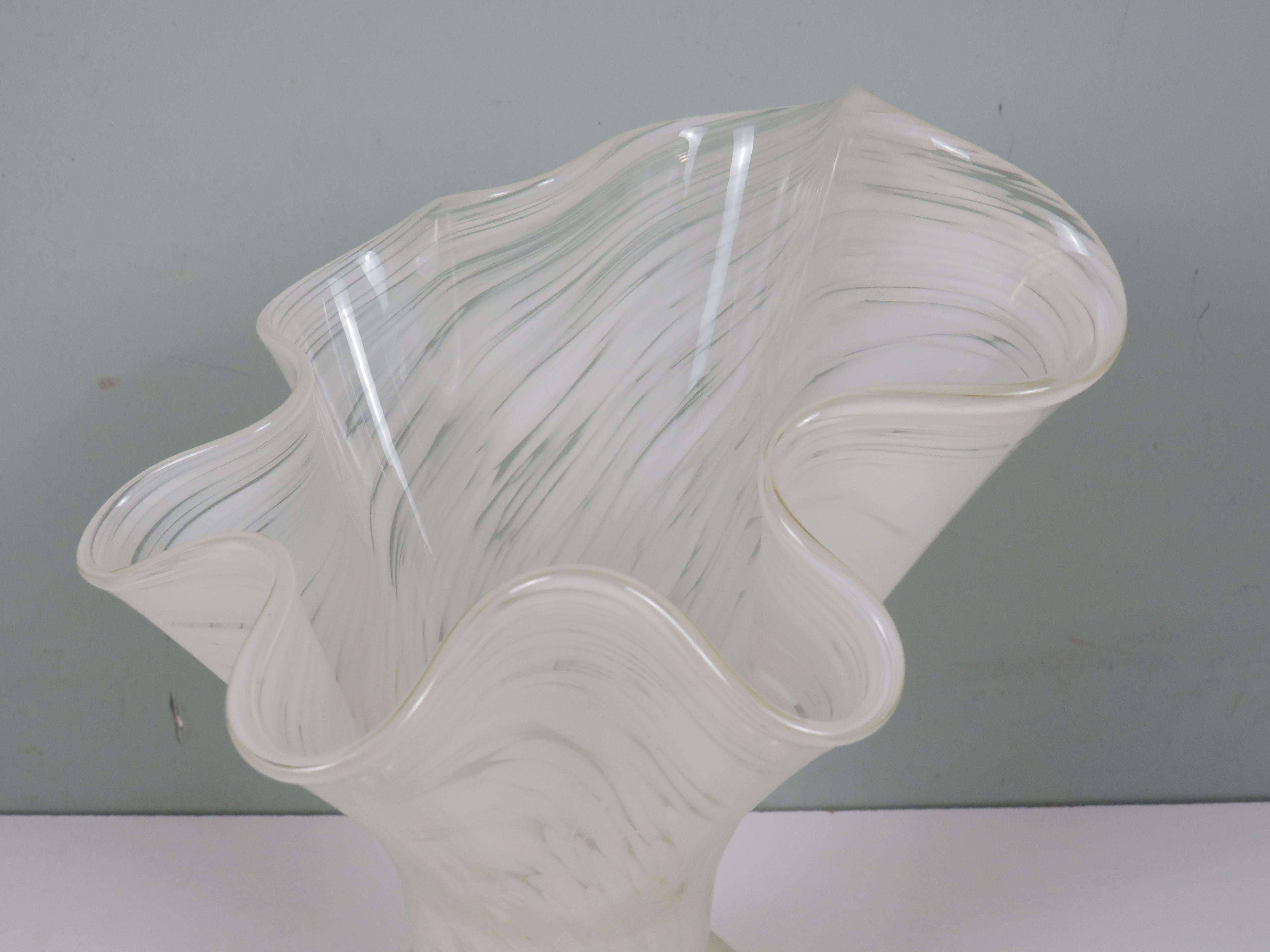 A superb example of Venetian artistry, this white Murano glass vase from the 1970s embodies timeless elegance and craftsmanship. Its sculptural silhouette — a full, rounded base rising into a softly flared, wavy rim — captures the essence of light