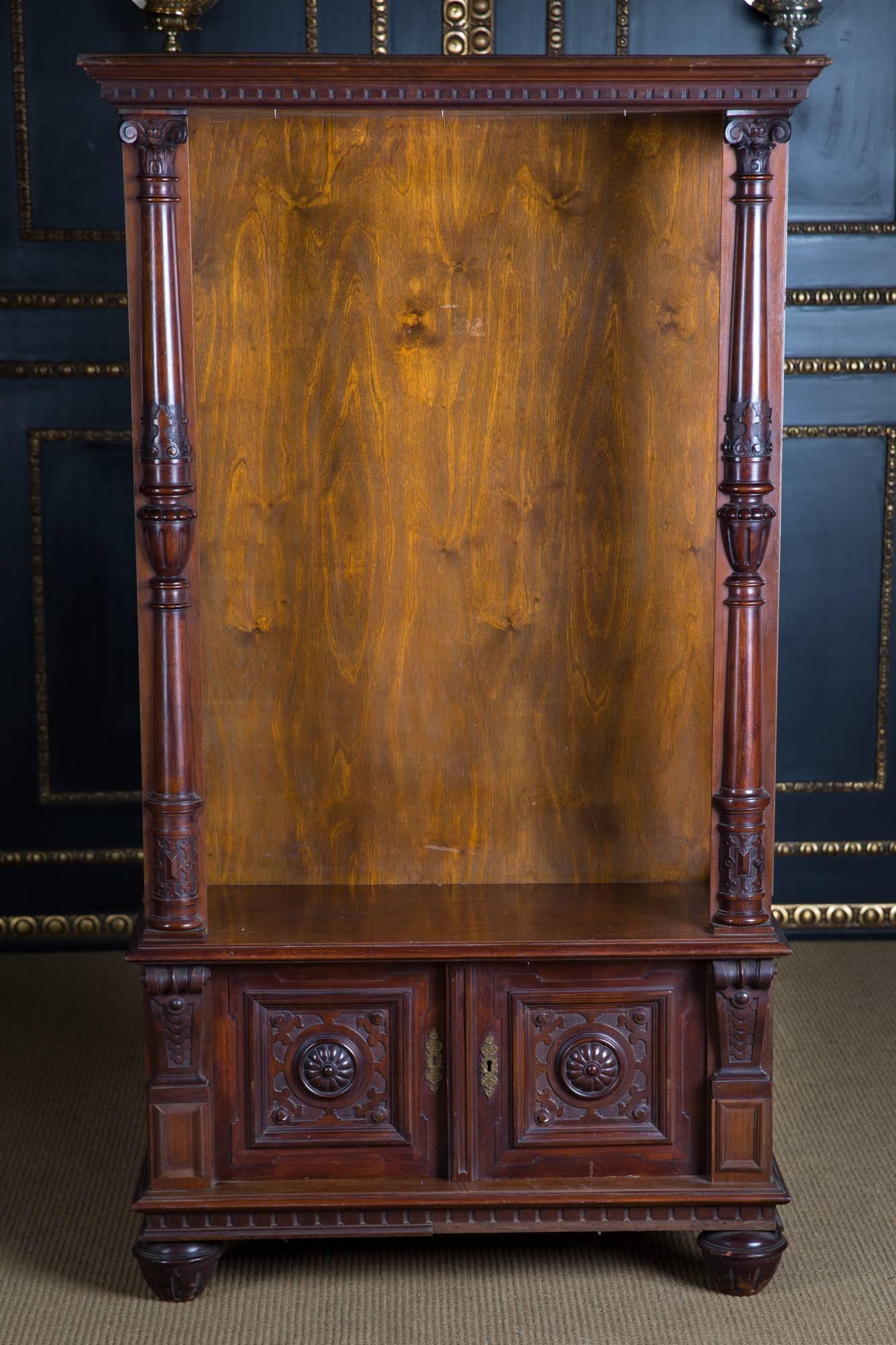 High-rectangular body on pressed ball feet. Above open, flanked by three-quarter carved columns. Including two fully carved doors.

The wardrobe was once a showcase, converted into an open showcase.

Originates from a Berlin estate.

Excellent