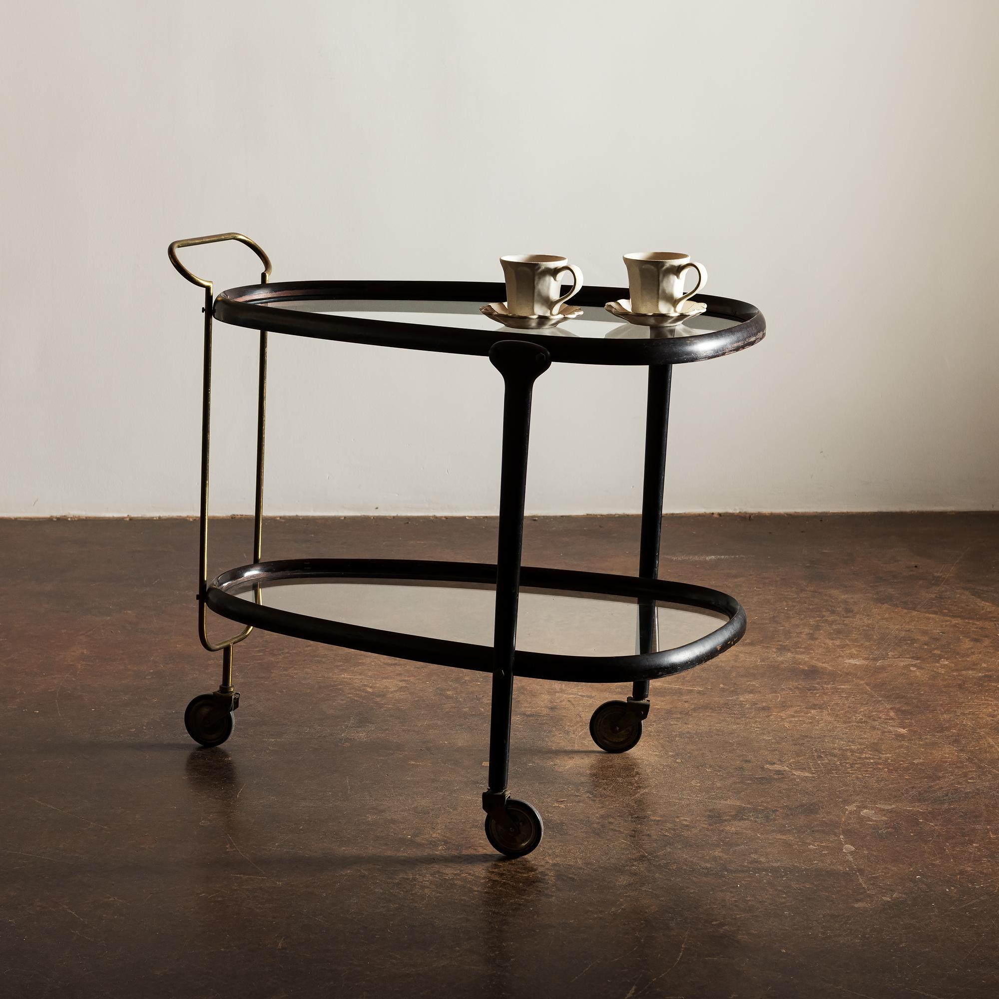 Handsome Italian bar cart with lovely form in lacquered wood and tubular brass handle original wheels are fully functional.