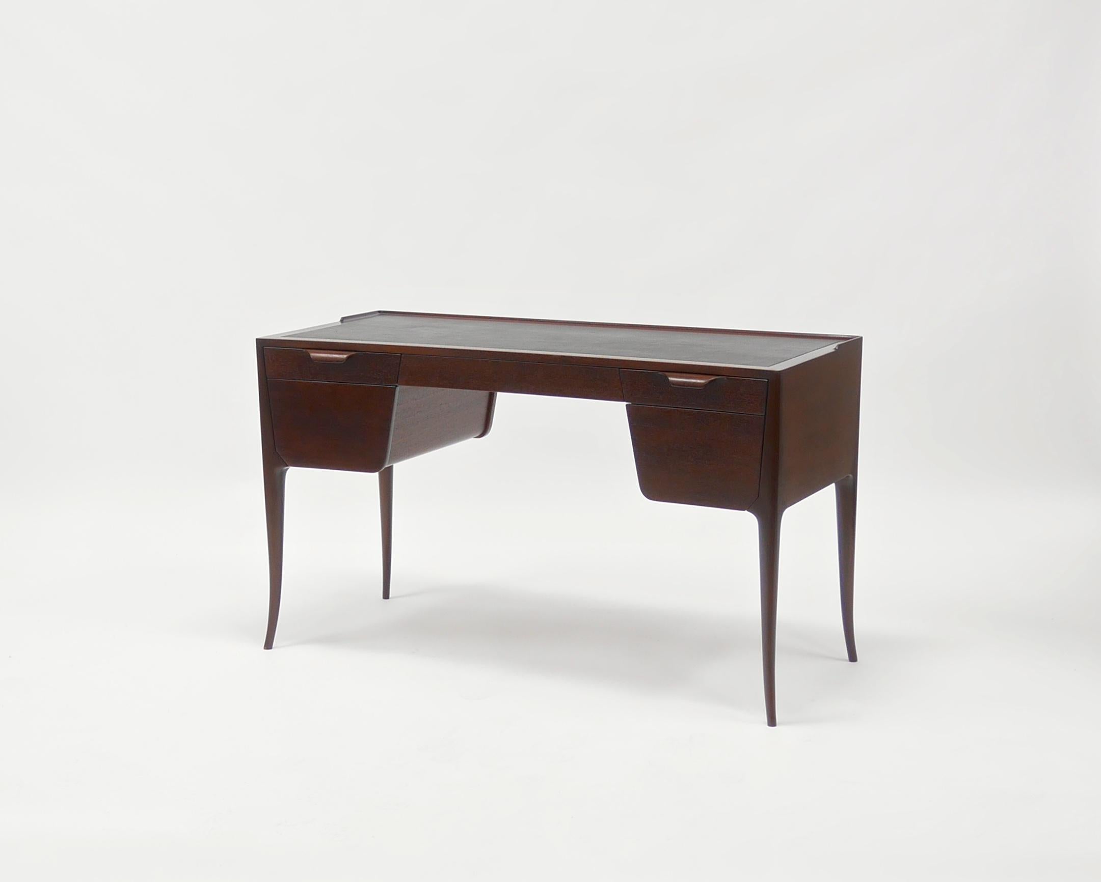 Rare and beautifully made writing desk by Edward Wormley for Dunbar. Having five drawers, saber legs, a curved front and a leather writing surface.