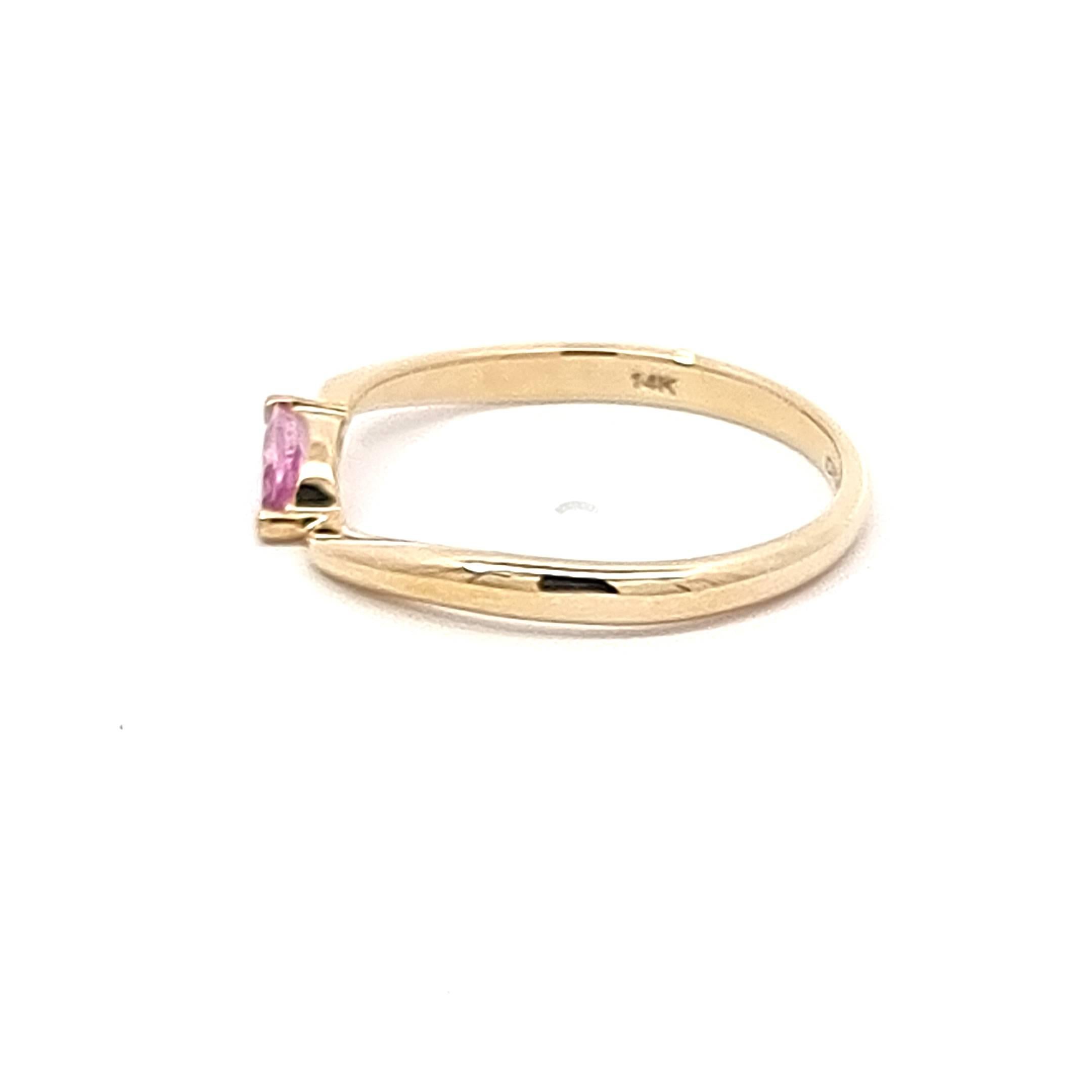Step into a world of enchantment with our 14K Yellow Gold Ring, a celebration of delicate beauty and sophistication. The centerpiece, a mesmerizing pink marquise sapphire weighing 0.27 carats, emanates a soft, rosy glow that captures the essence of