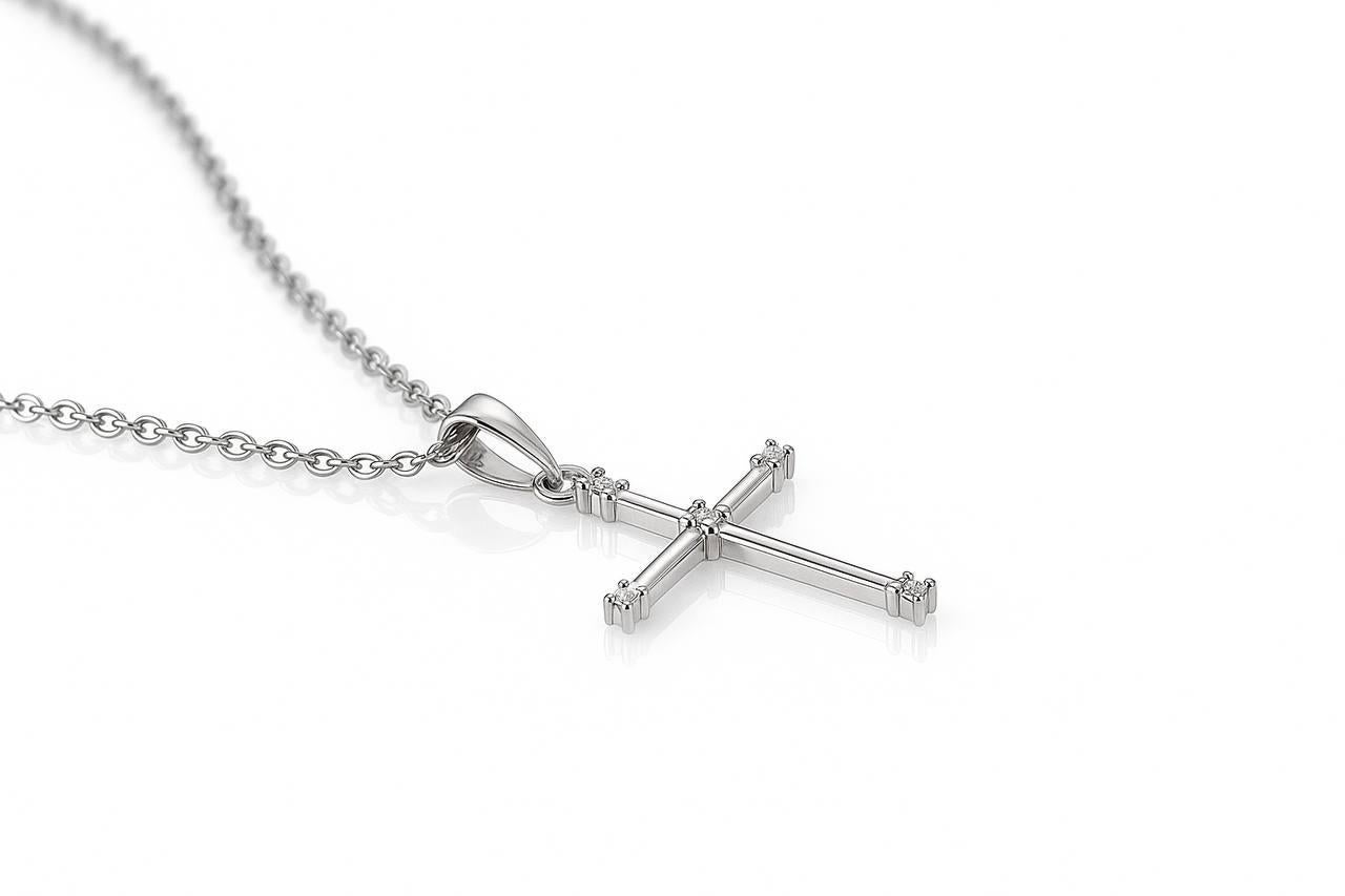 Eleganter, kreuzförmiger Anhänger aus 18 Karat Gold, hergestellt in Frankreich, mit einem raffinierten und zeitlosen Design. Das Schmuckstück ist mit ca. 0,20 Karat Diamanten besetzt, die ihm einen zarten Glanz verleihen und gleichzeitig eine klare,