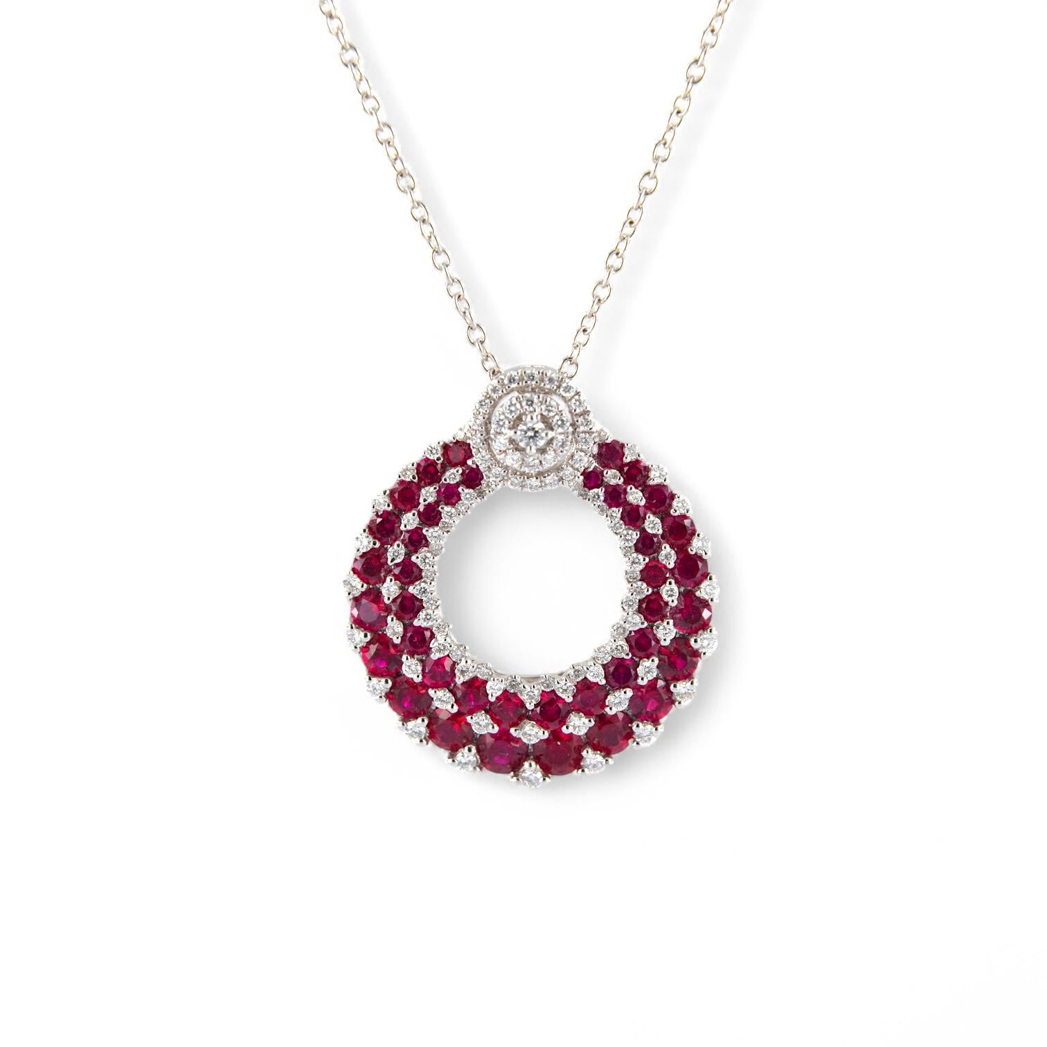 Un gioiello dal fascino sofisticato e senza tempo: questa raffinata collana presenta un ciondolo circolare realizzato in oro bianco 18 carati, ornato da un incantevole pavé di rubini naturali (2.29 ct) e diamanti bianchi (0.56 ct). Il disegno