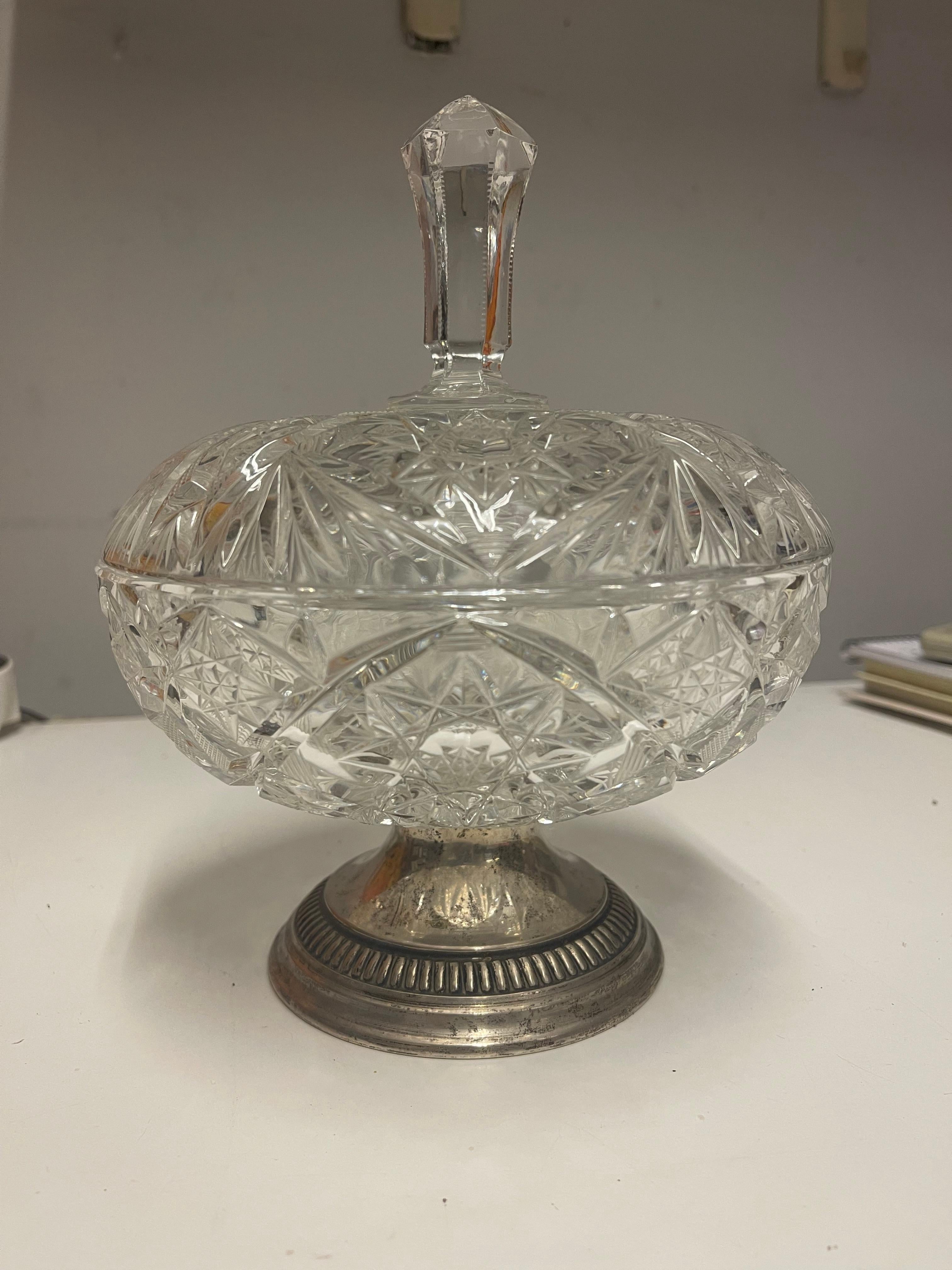 Splendida ciotola in cristallo vintage. Caratterizzato da un'elegante lavorazione a taglio e una base in tono argento, questo pezzo raffinato è perfetto per esporre gioielli, caramelle o come elemento decorativo in ogni stanza. Il suo design senza