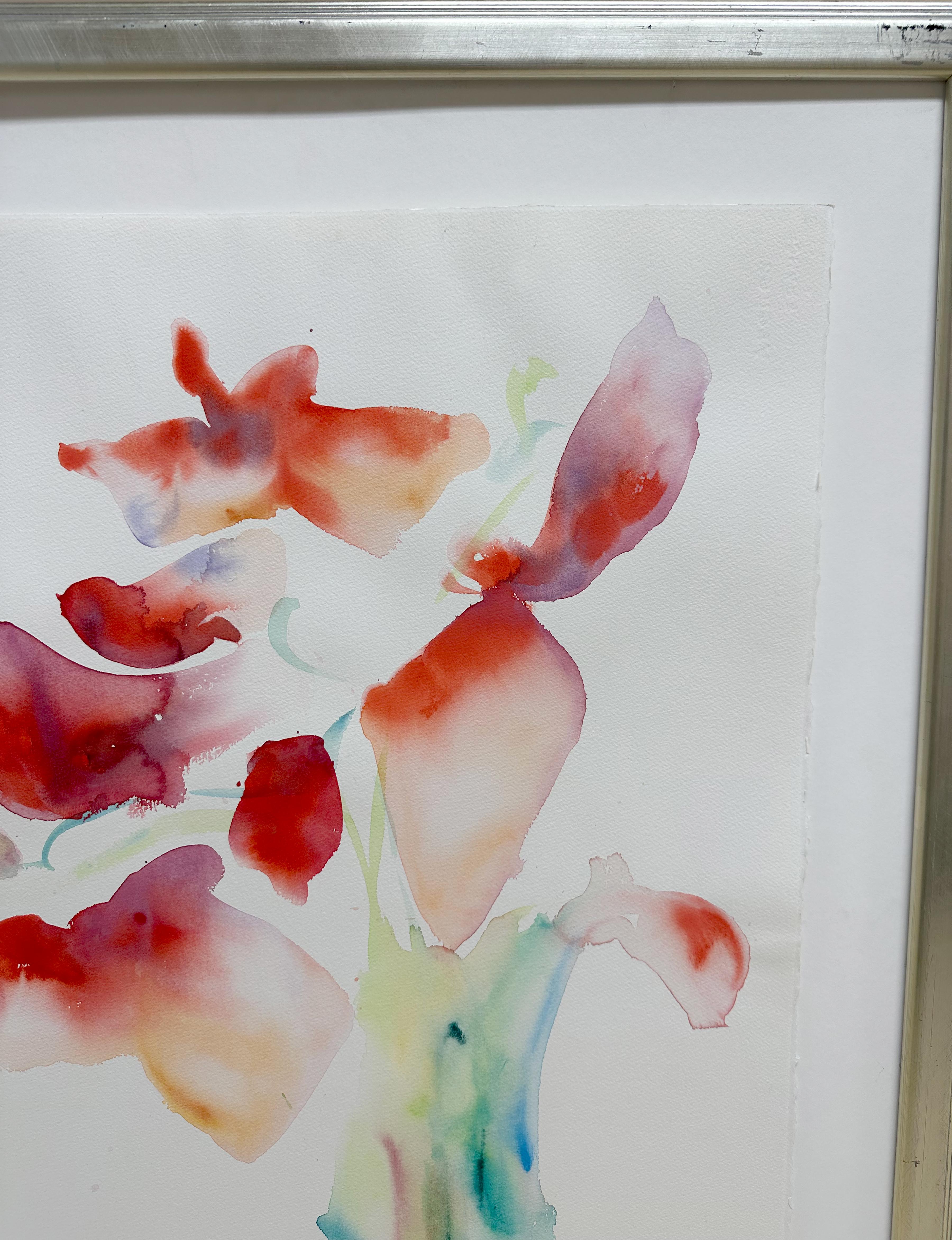 An elegant and vibrant framed original floral watercolor painting. both minimal and soulful in its use of color. Painting by artist J. George. Silver frame with a glass cover and a white matte. The framed abstract floral form is made up of subtle