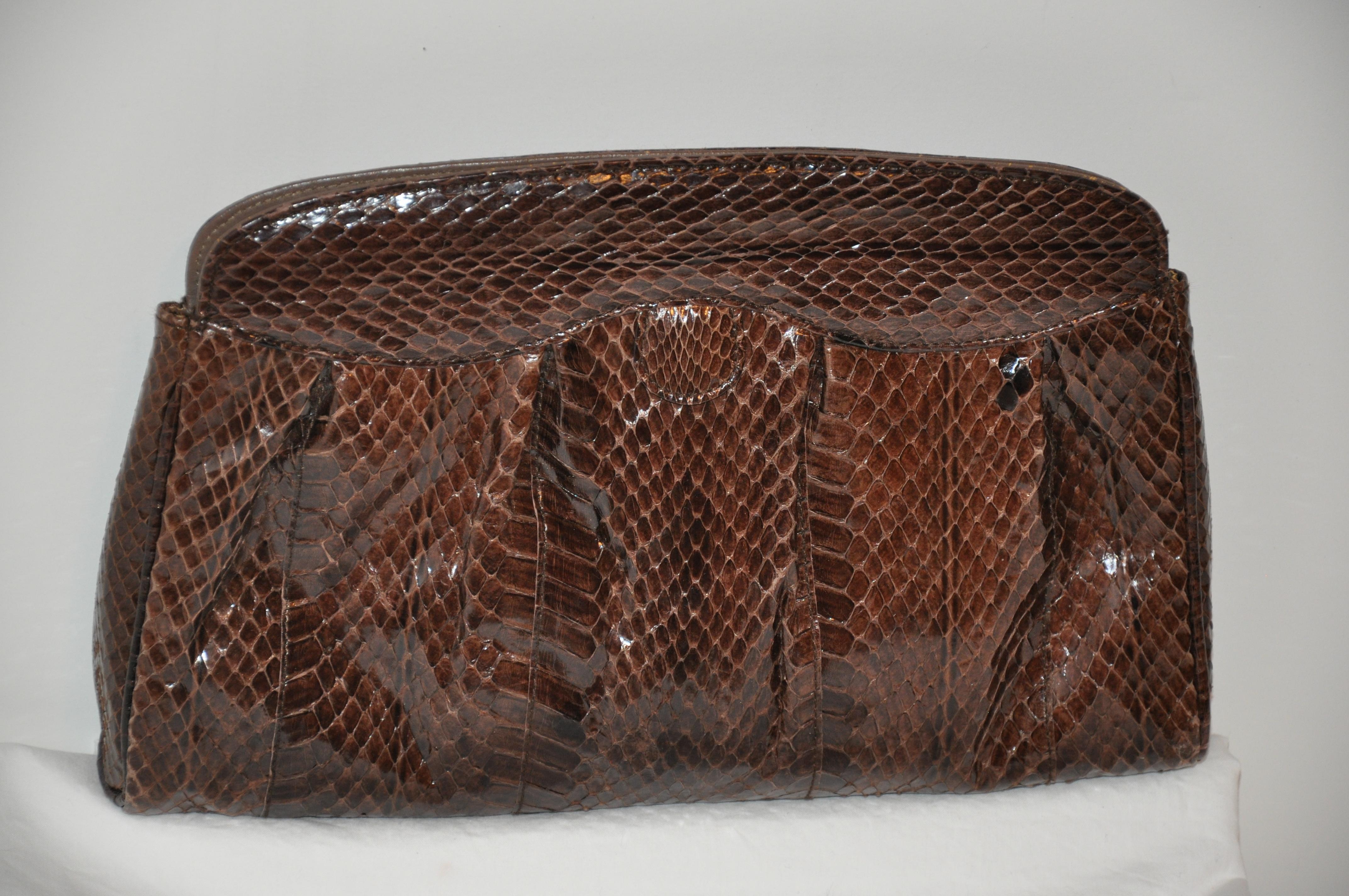       This wonderfully elegant warm coco-brown snakeskin clutch has a 