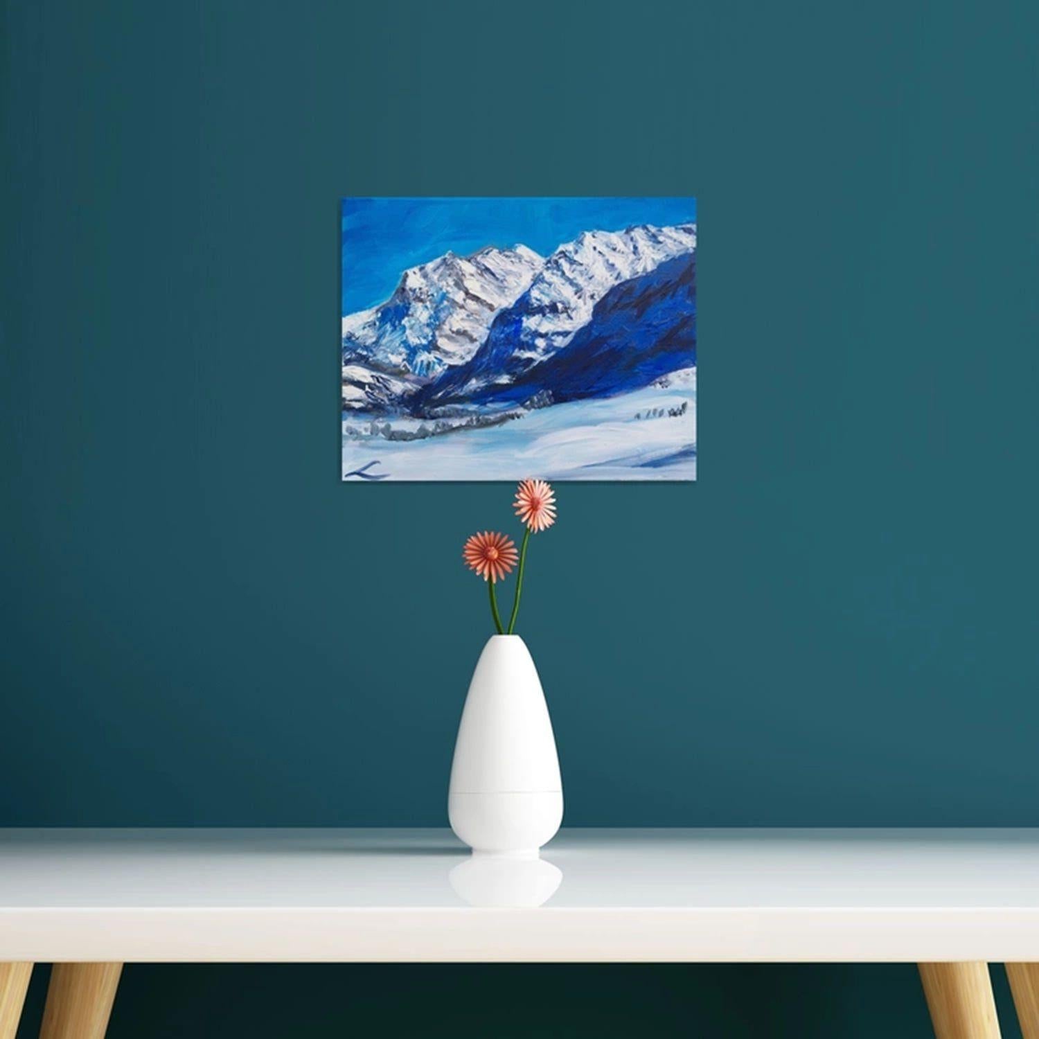La imagen representa un óleo original con una cordillera nevada sobre un cielo azul brillante. Las montañas se muestran con un lado iluminado por la luz del sol y el otro en sombra, presentando un marcado contraste en el que el lado sombreado