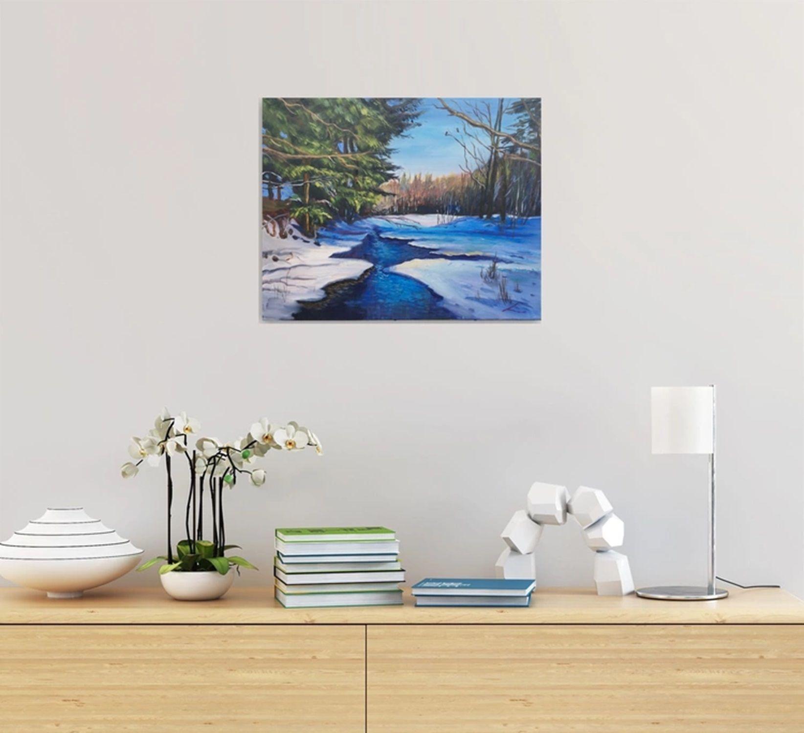 Dargestellt ist eine ruhige Winterlandschaft mit einem verschneiten Fluss, der sich durch einen Wald schlängelt. Das Flussufer ist schneebedeckt und wird von üppigen, immergrünen Kiefern auf der einen und blattlosen Bäumen auf der anderen Seite
