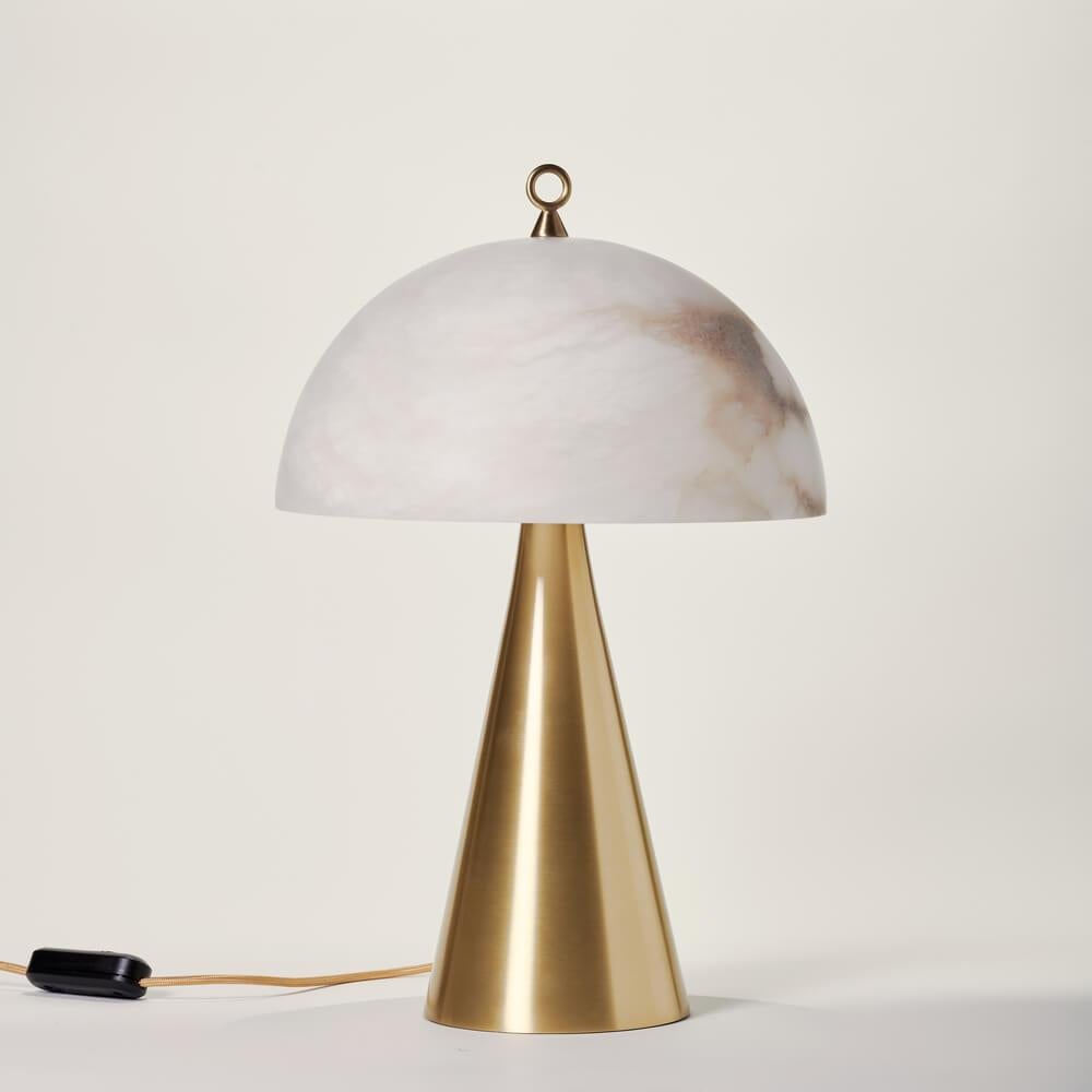 Born from the success of our Funghetto model, the Fungotto table lamp has larger and bolder dimensions, while maintaining the simplicity of its shapes. Il paralume semisferico in alabastro, con le sue venature enfatizzate dalla luce, è completato