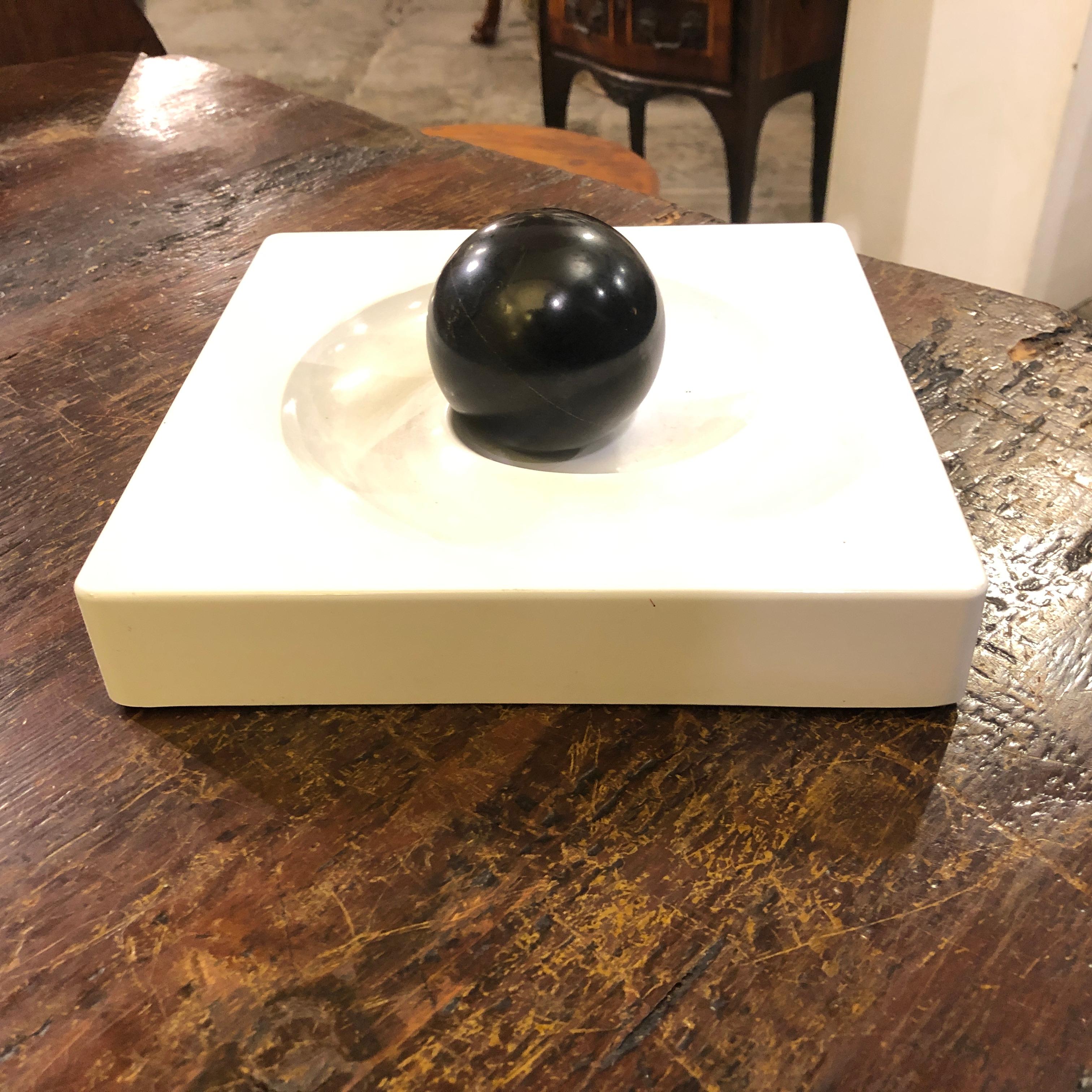 Black and white squared centrepiece by Eleonore Peduzzi Riva for Artemide. White base with downward trace that allows the sphere to run until the middle. It's in perfect conditions.