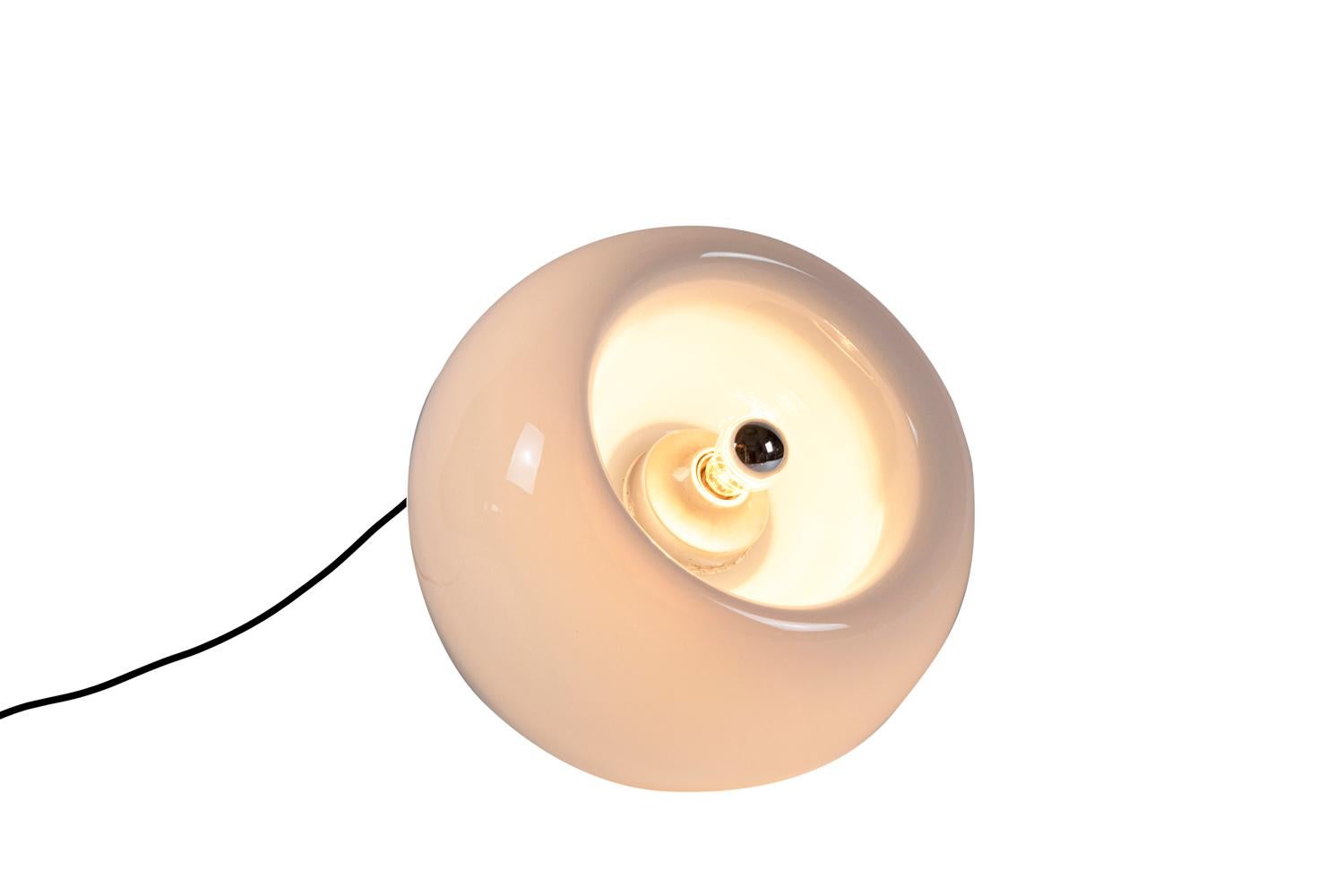 Eleonore Peduzzi-Riva for Artemide, attibuted to.
Spherical-shaped “Vacuna” lamp in white tainted Murano glass with concave recess. It can be placed in two different positions.

Work realized in 1968.

Functional electrical system.

Another
