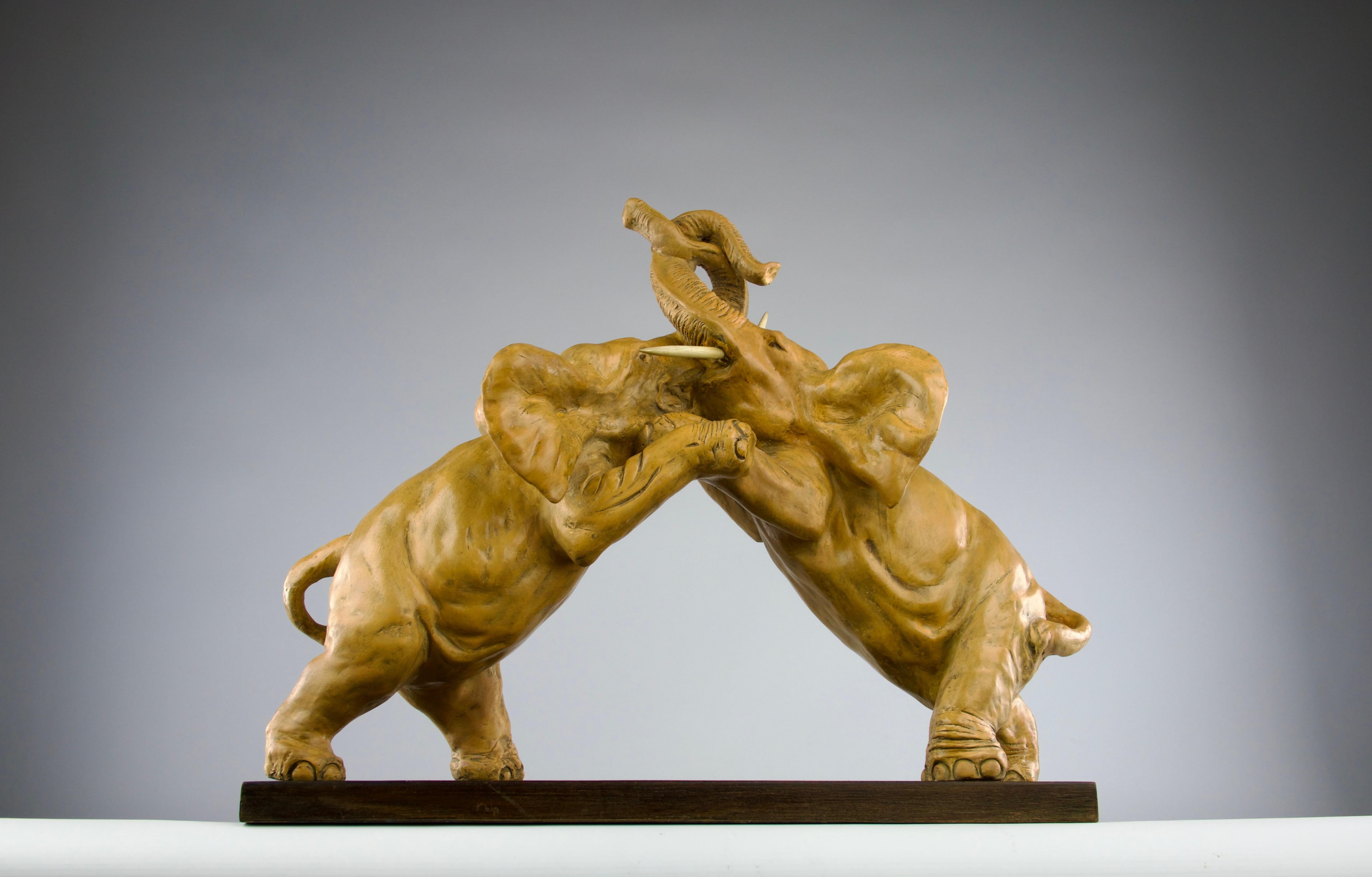 Superb patinated earthenware sculpture representing two elephants fighting, France 1800s, Romantic period. Beautiful details enhancing the vivacity of the piece with slight hues of red simulating blood from the fight. Tusks made of painted wood.

In