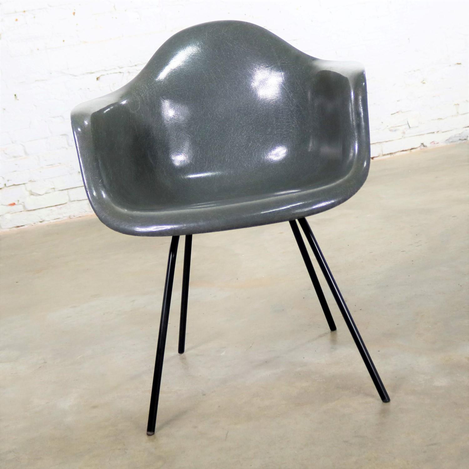 Magnifique exemple de la chaise DAX à accoudoirs en fibre de verre de Charles et Ray Eames pour Herman Miller. Il est en peau d'éléphant grise avec une base H noire et des pieds glissants inhabituels. Il conserve une étiquette en papier mais ne