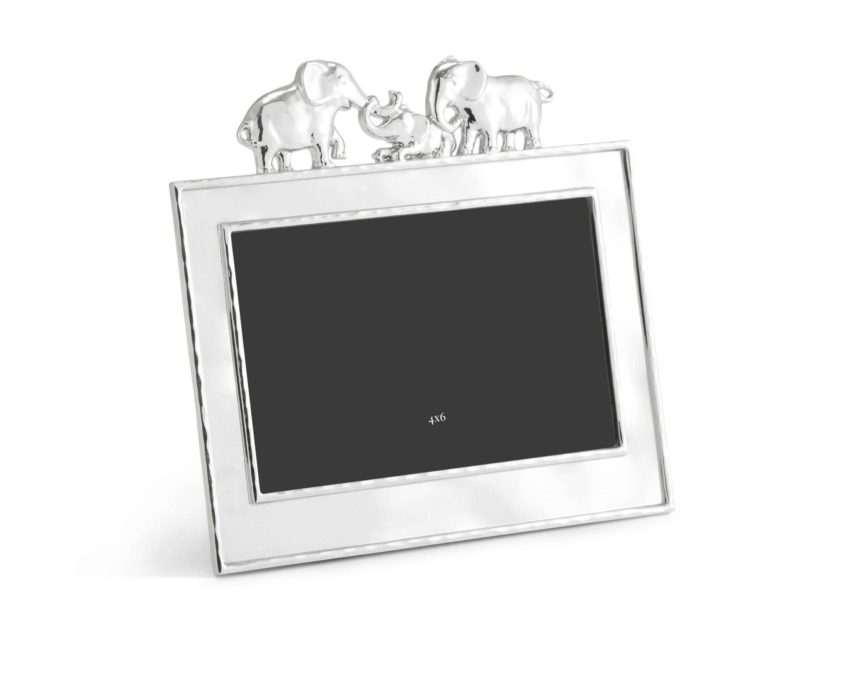 Marco de fotos de elefante con borde blanco, en metal plateado y esmalte, modelo pequeño.

Acaricia los momentos felices pasados con tus pequeños en este adorable marco de fotos familiar con forma de elefante. Fabricado en metal plateado y
