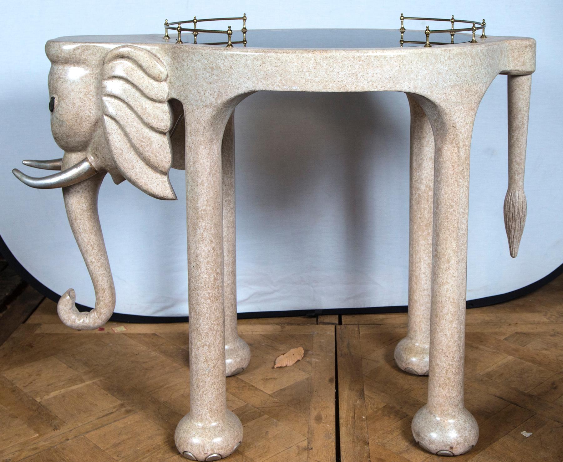Table ou chariot de bar à roulettes éléphant Marge Carson. Fabriqué en bois de composition avec un plateau en verre teinté et des rails en laiton.