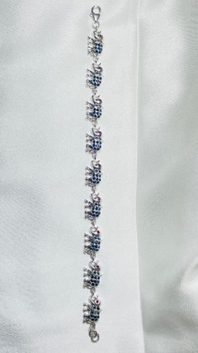 Elephant Sapphire Ruby Charm Bracelet Gift for Her in sterling silver showcases endlessly sparkling natural smoky topaz, weighing 3.78 carat. It measures 7.5 inches long in length. 
Sapphire, Ruby stimulate concentration and reduces stress.