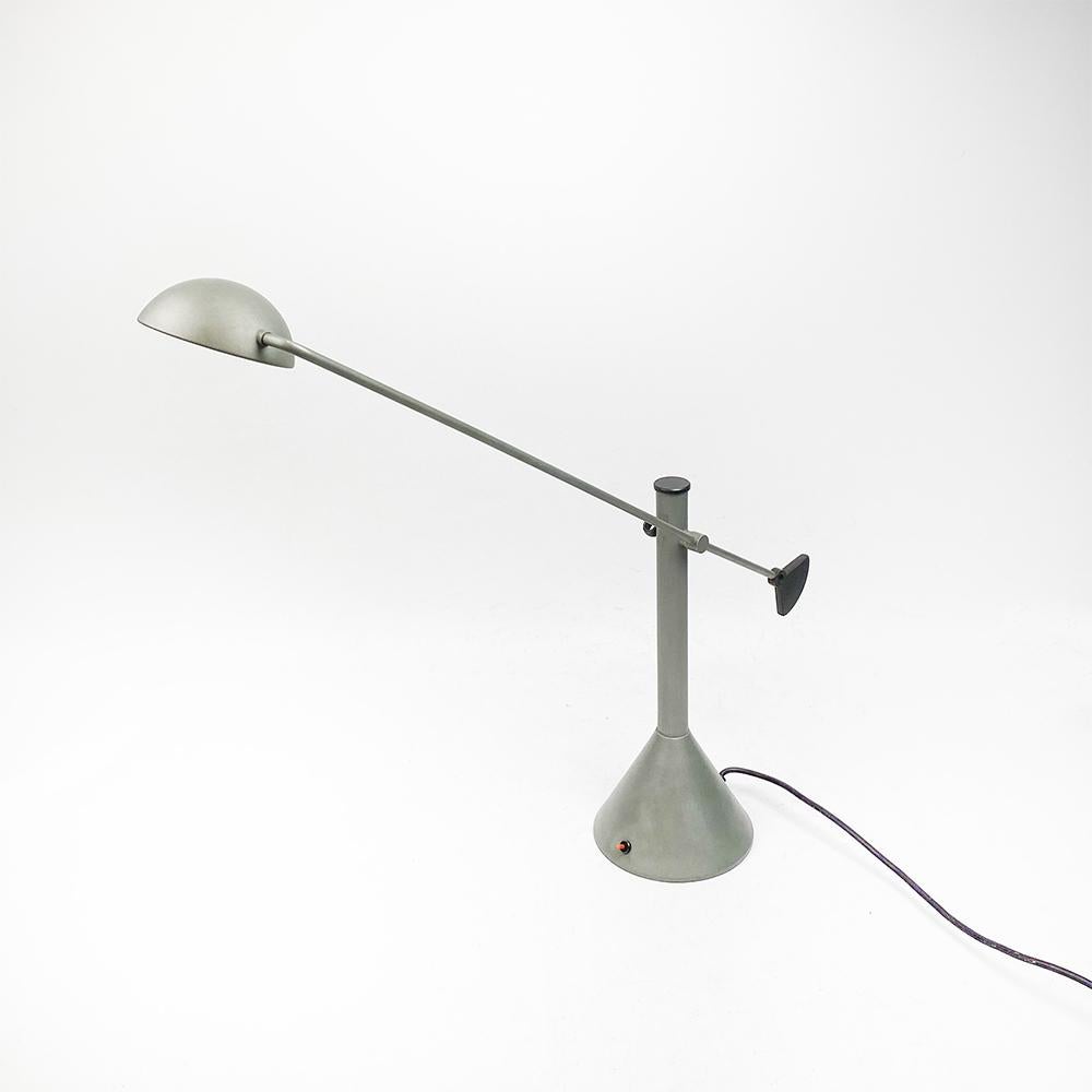 Eleusi table top lamp design by Inao Miura, 1985.

Rocker arm Gray lacquered metal body and arm. Black lacquered metal trims.

Halogen light with two positions. 

Medidas: 75 x 38 x 17 cm.