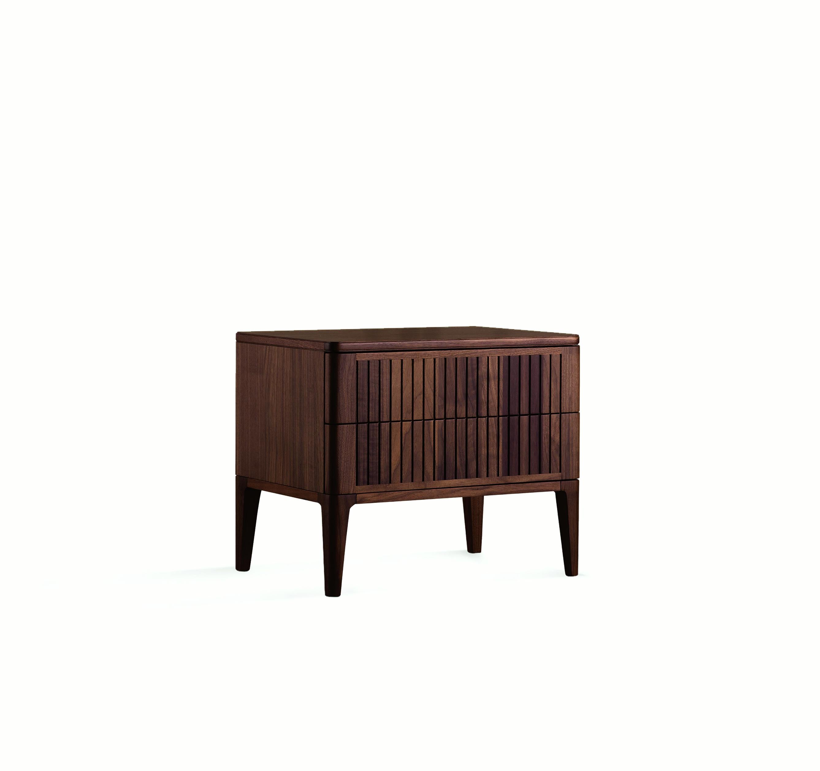 The Eleva solid wood bedside tables combine refined Italian design and skilled craftsmanship. The front doors, made of premium solid walnut with acrylic finish, create an intriguing contrast between light and shadow thanks to a linear style.