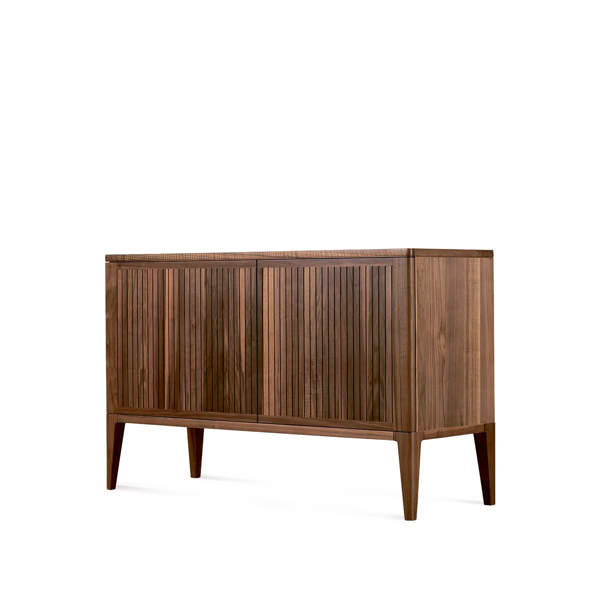 This sideboard is the result of the combination of fine Italian design and superior craftsmanship. The crafted front of the two doors made in premium solid walnut, oil finish, creates a stunning contrast between light and shadows thanks to it’s