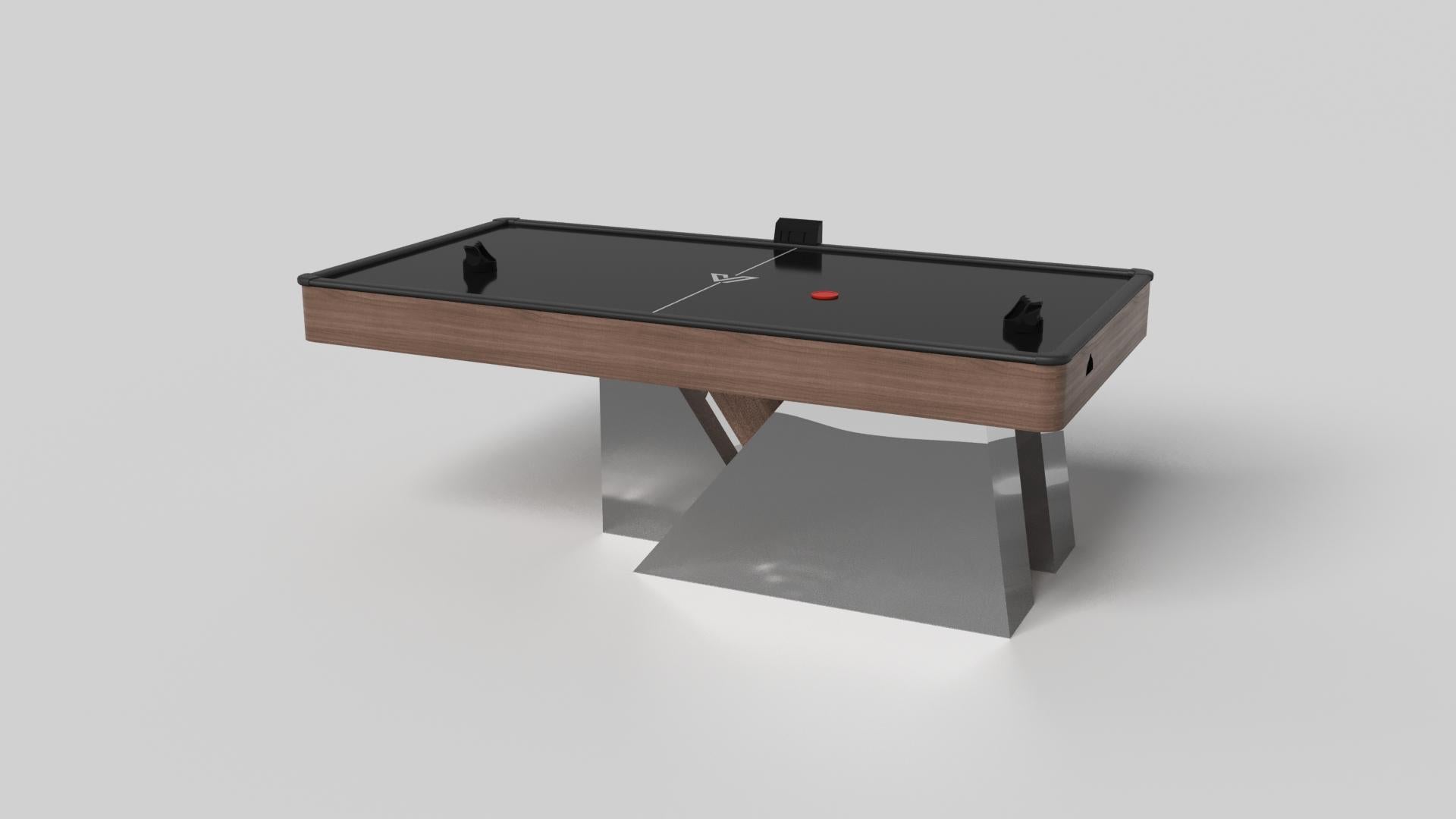 An asymmetric base creates a free-floating silhouette, making the Stilt air hockey table in chrome with walnut a compelling, contemporary addition to the modern home. Crafted from durable metal with solid walnut wood accents, this luxury handcrafted