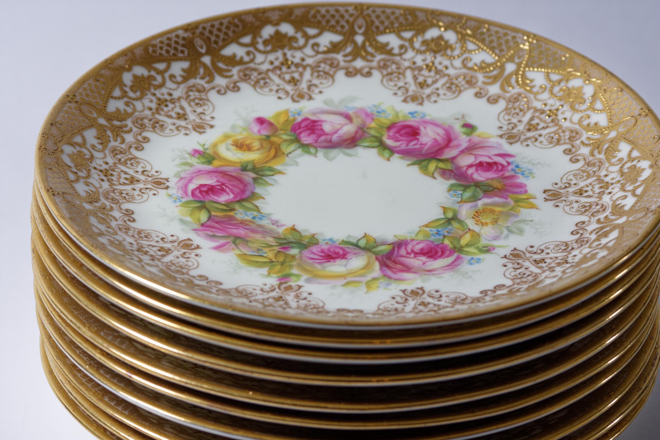 A very pretty set of 11 plates with hand painted roses and raised tooled gilding. They were made by the storied Gilded Age firm of Cauldon England and custom ordered through the famed Fifth Ave retailer of Davis Collamore. The artist that created