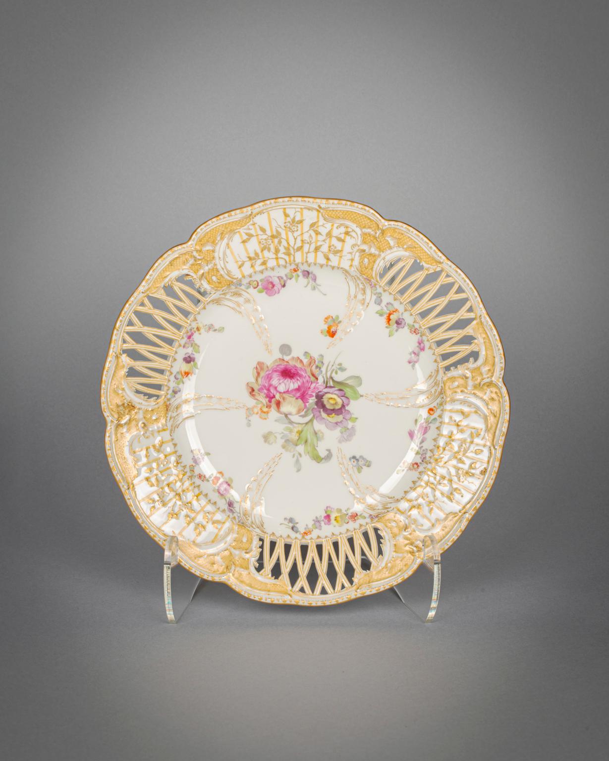 The well finely painted with a central floral bouquet and with six molded gilded leaves radiating outwards alternating with smaller flowers, the three open work border panels alternating with molded gilded leaves. 