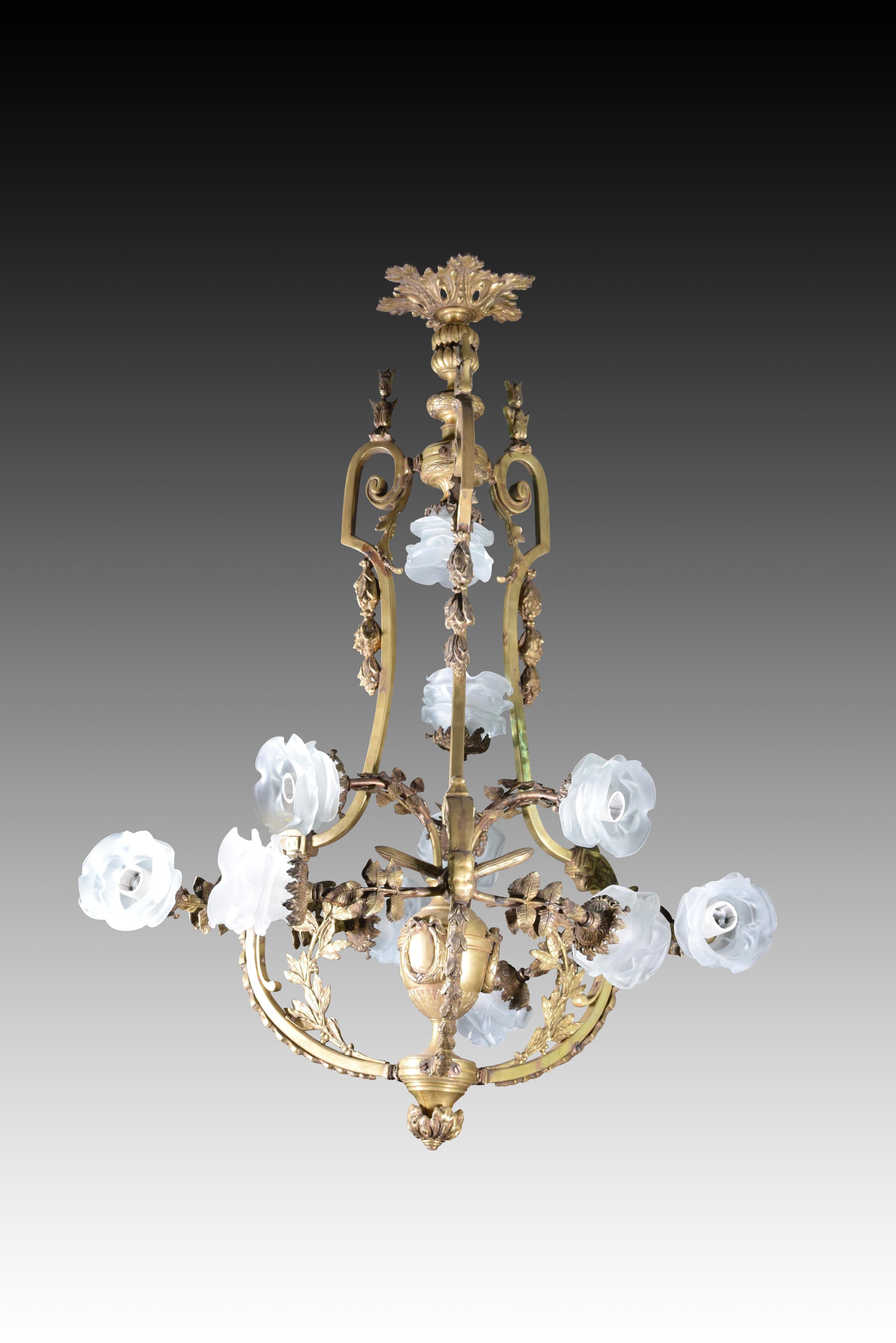 Eleven-light ceiling lamp. Bronze with aged finish.
 The central body of the lamp is formed by a vase with garlands resting on a round molding. From the upper part start a series of stems that end in the lights, whose curved stem has been made from