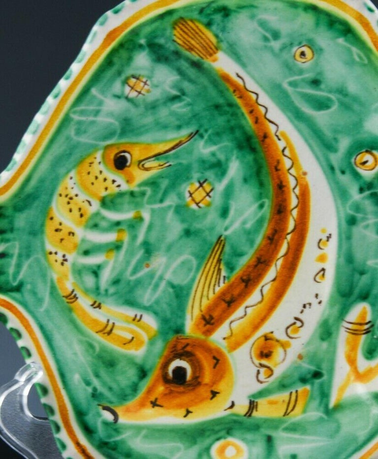 Eleven Mid-Century Modern Italian pottery fish plates,
Vietri
Dated 1958,

Each plate is modeled in the form of a fish and each is painted with a different fish or sea life on an orange and green ground.

Mark: C.A.S/ Vietri/Italy/ AD