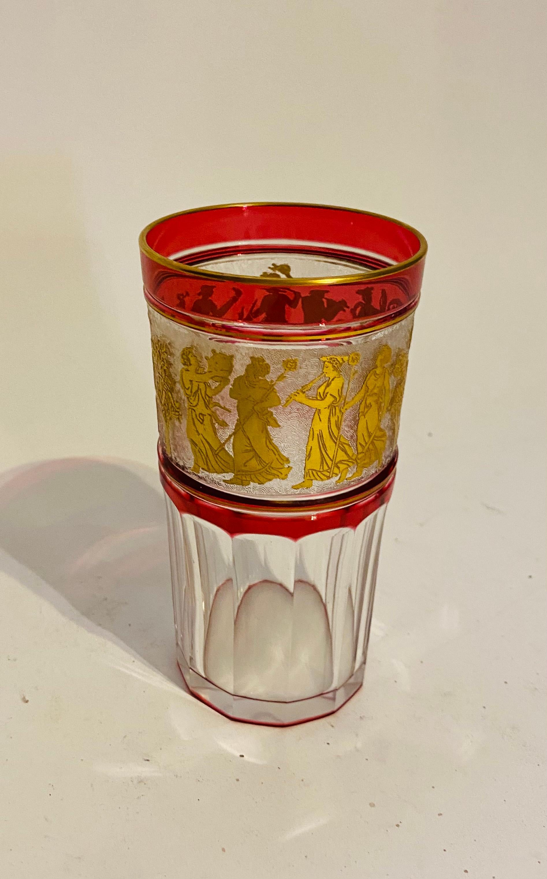 A great set of 11 Bar or water glasses from the premier crystal firm of Val Saint Lambert. This is one of their classic designs of gilt Greco Roman cameo figures dancing on an acid etched back ground surrounded by a rich ruby/cranberry color.
