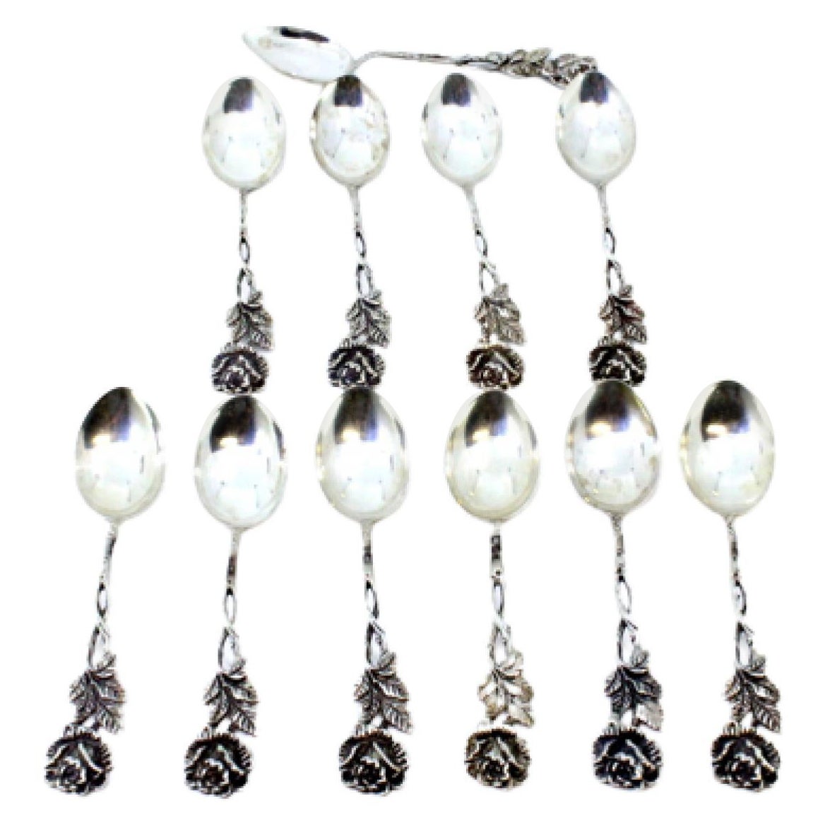 Eleven scalloped silver teaspoons with flower-shaped handles