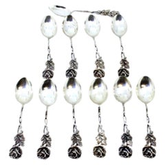 Eleven scalloped silver teaspoons with flower-shaped handles