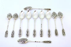 Eleven silver dessert spoons with Russian-style engraved shells and handles