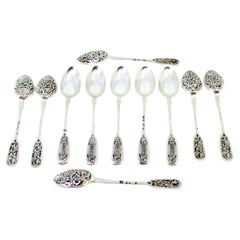 Eleven silver dessert spoons with Russian-style engraved shells and handles