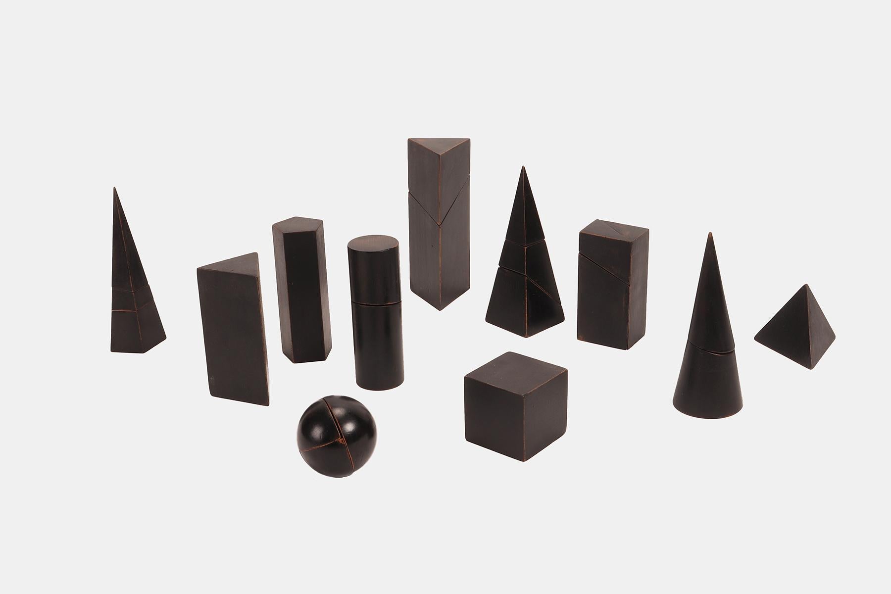 A box containing a group of 11 geometric solids made of ebonized black lacquered solid wood. Educational use. Castiglione, Turin, Italy 1900.