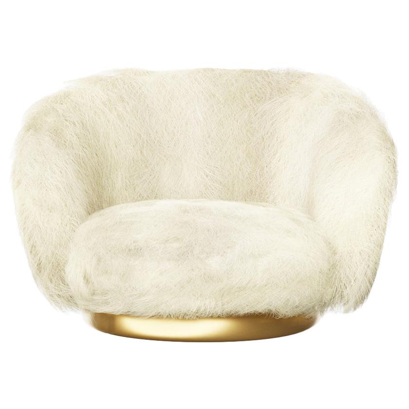 Featured in cream and brown Angora goatskin, this low seated lounge chair is made to order and available in alternative fabric options and COM. The return swivel base is finished in cast bronze. Bespoke metal and wood veneer options are available.