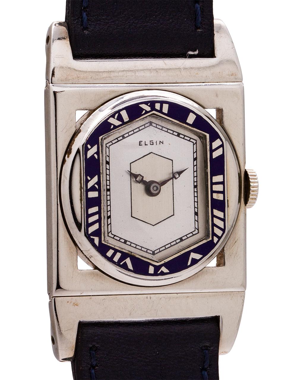 
Vintage Elgin 14K white gold  “Presentation” model circa 1929. Featuring an art deco inspired 26 x 40mm rectangular case with hinged lugs and distinctive blue enamel hexagonal shaped Roman numeral chapter ring.  With a nicely restored 2 tone satin