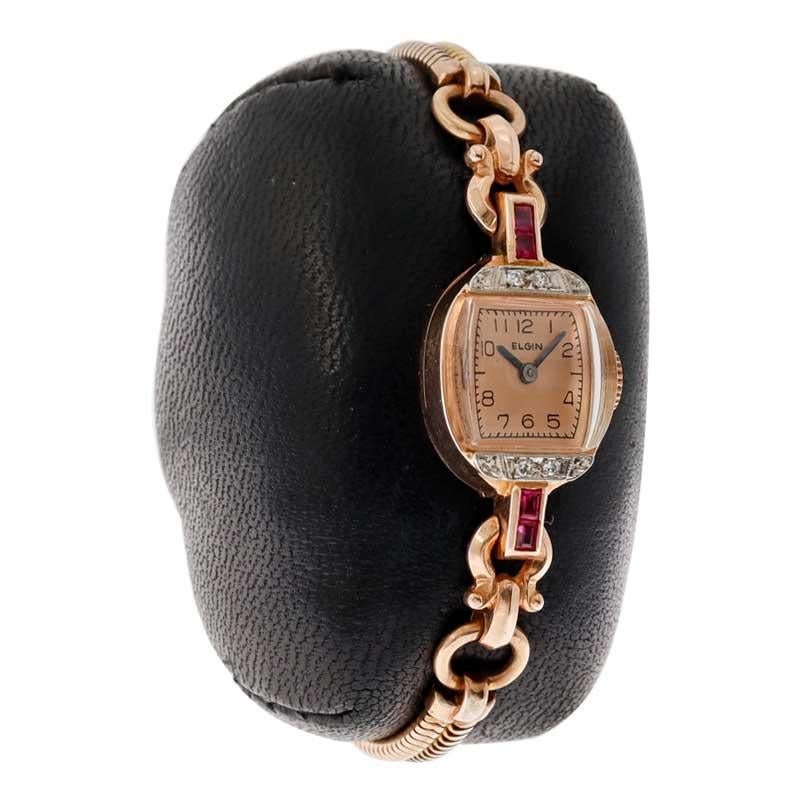FACTORY / HOUSE: Elgin Watch Company
STYLE / REFERENCE: Art Deco
METAL / MATERIAL: 14kt Rose Gold / Diamonds and Rubies / Gold Filled Bracelet
CIRCA / YEAR: 1940's
DIMENSIONS / SIZE: Length 28mm X Width 14mm
MOVEMENT / CALIBER: Manual Winding / 19