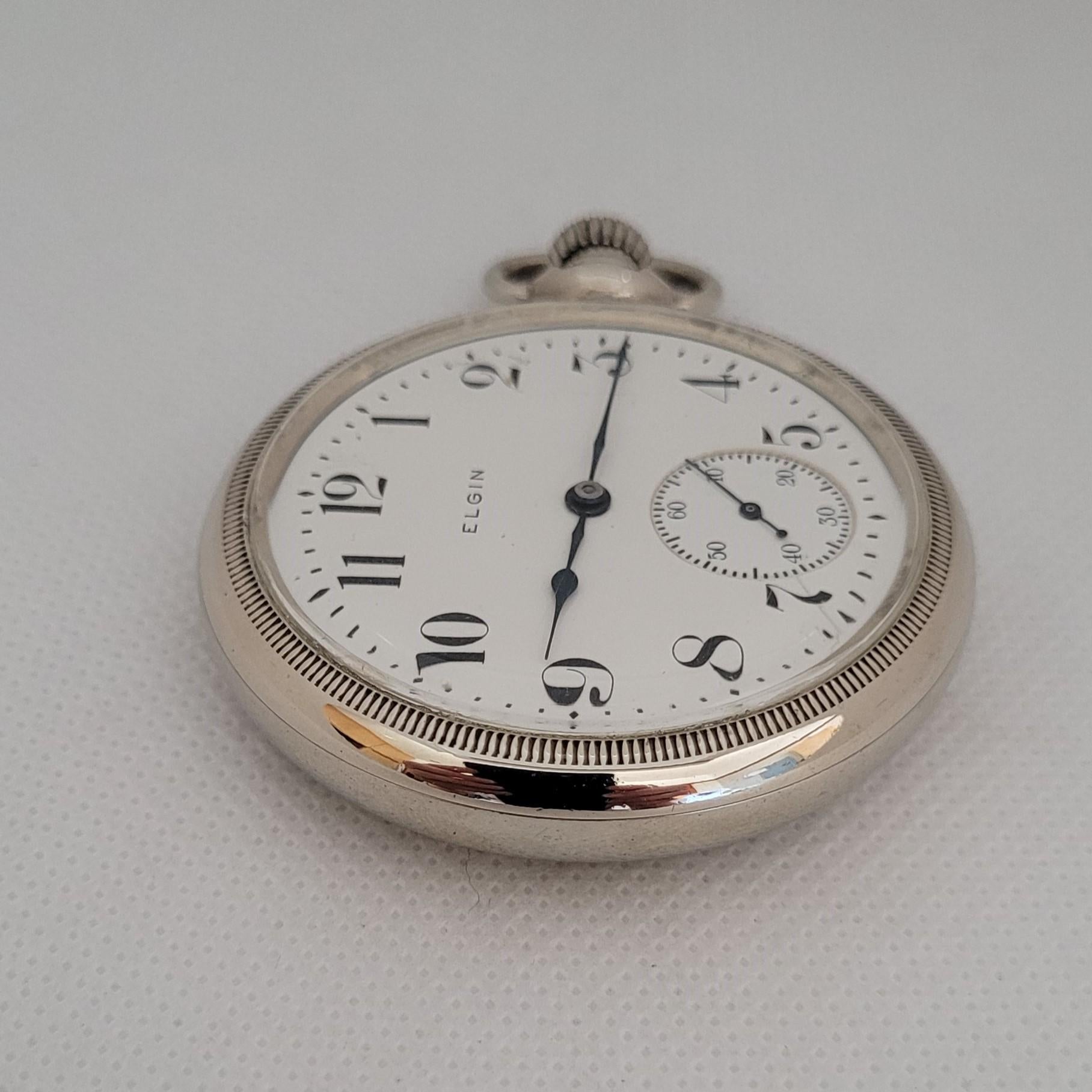 Diese 53 mm große Elgin-Taschenuhr von 1906 mit weißem Zifferblatt ist ein atemberaubender Zeitmesser, der mit Präzision und Eleganz gefertigt wurde. Mit einem Gewicht von 95,9 Gramm ist diese silberfarbene Uhr nicht nur optisch ansprechend, sondern