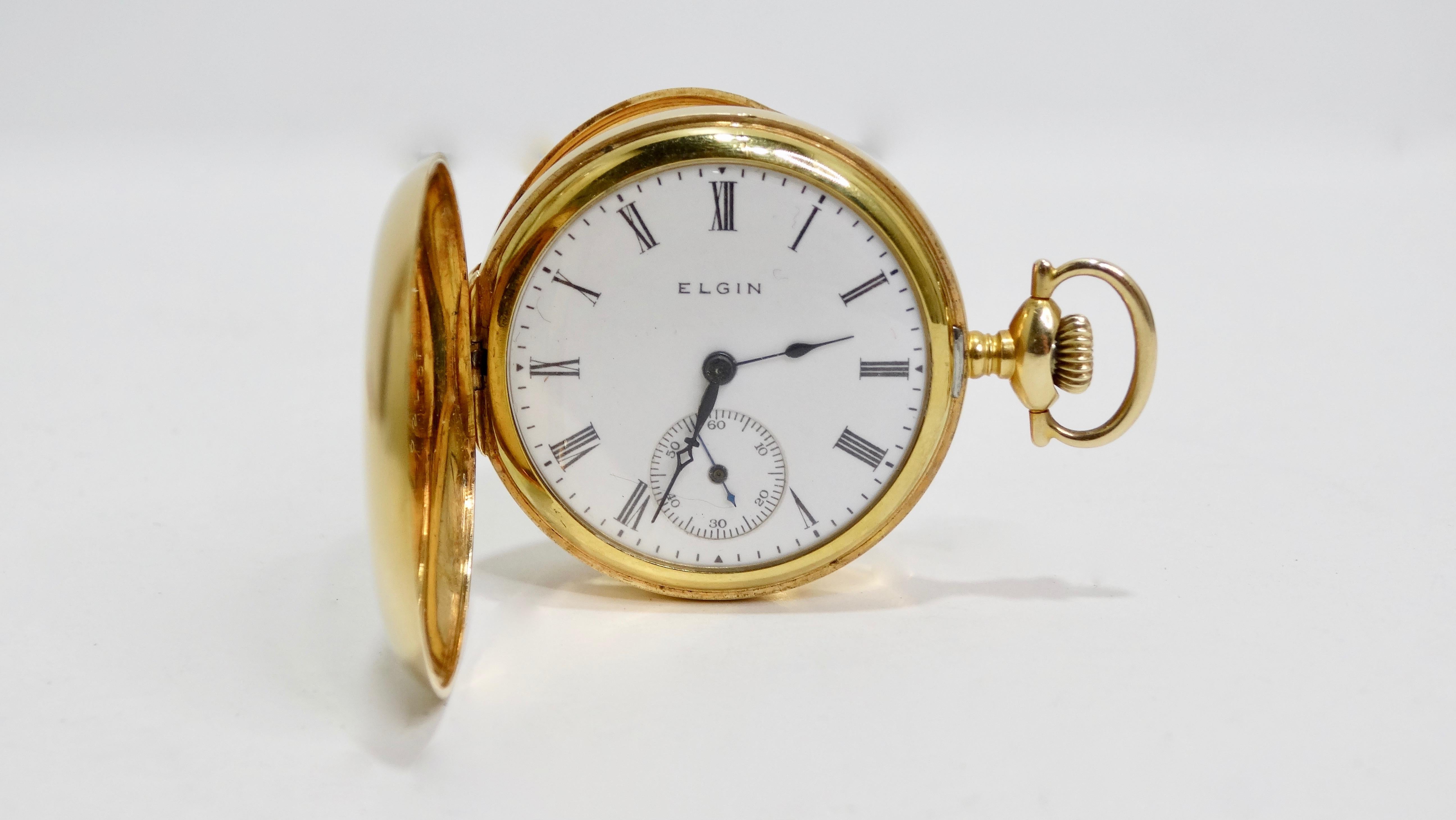 Add this unique time piece to your collection! Circa 1920s/1930s, this 14k Gold Elgin 40mm pocket watch features two engraved cases; one with a mini starburst that's set with a Ruby and the other displays a decorative design. Case opens up to a