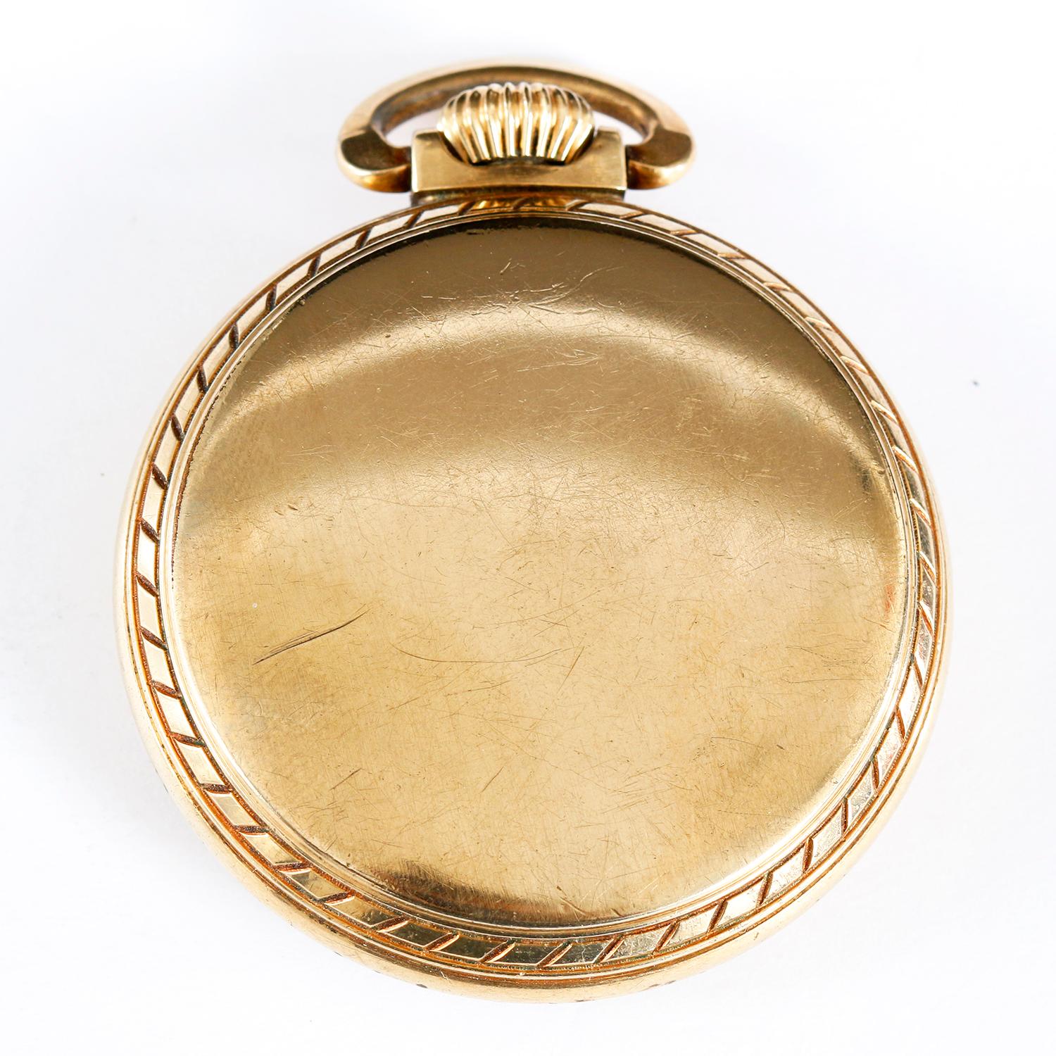 Reloj de bolsillo abierto Elgin Grado 575 - cuerda manual; 15 rubíes. Relleno de oro ( 49 mm). Esfera blanca con números arábigos y subesfera a las 6. Seminuevo con caja personalizada. Alrededor de 1950.