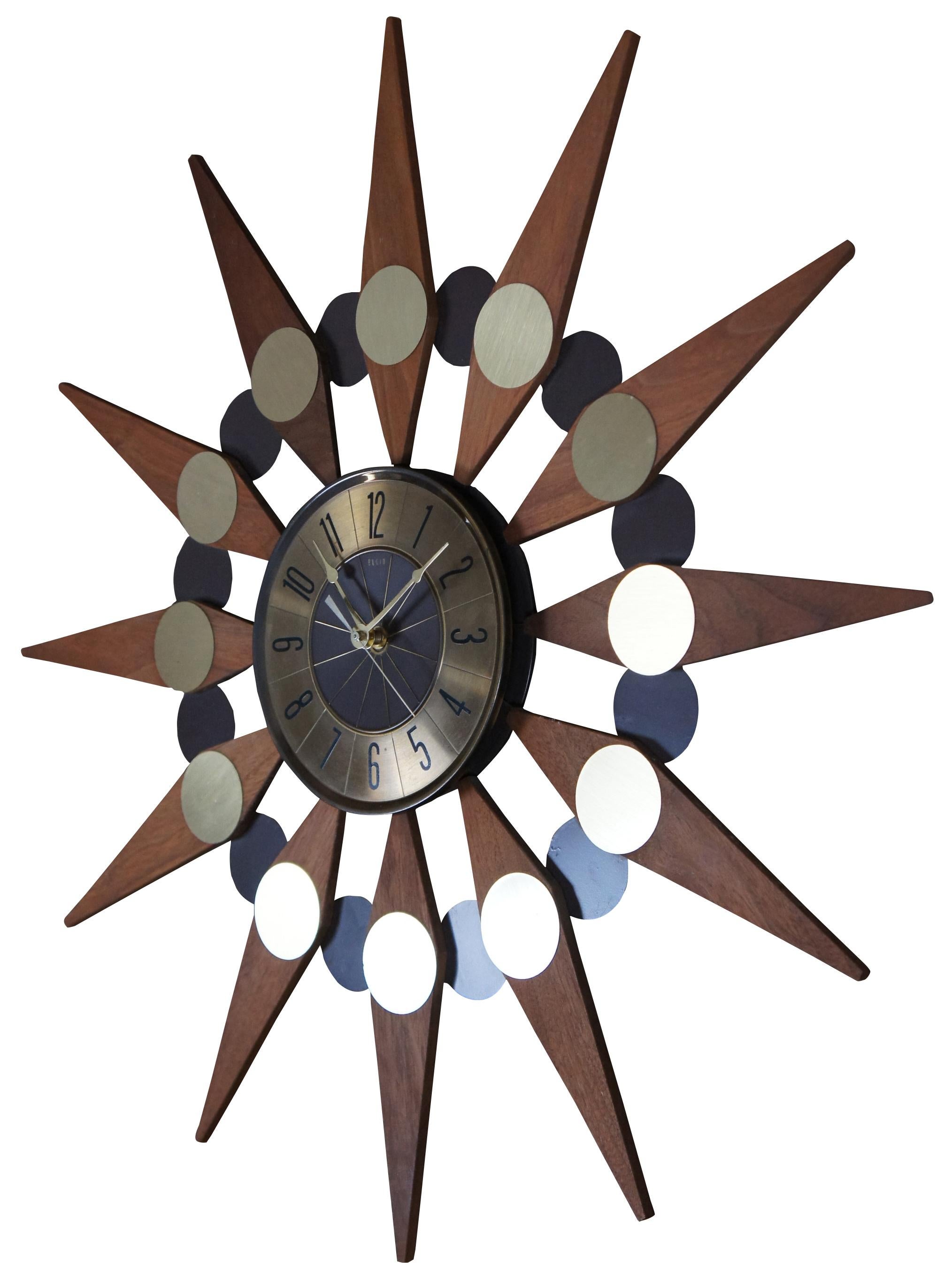 Vintage Mid-Century Modern wood and brass sunburst wall hanging clock with battery operated works. Measure: 25”.
 