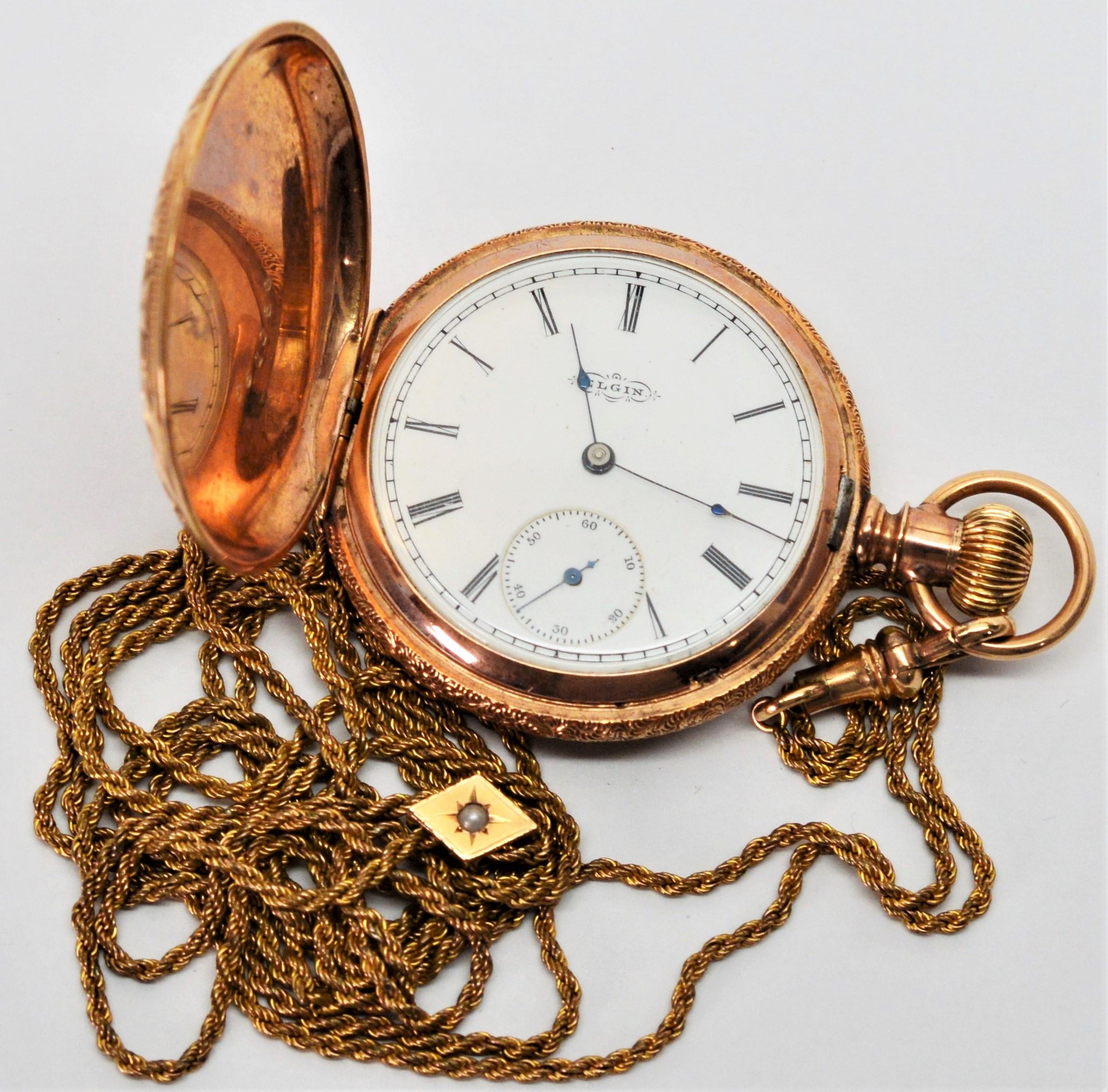 Circa 1891, Elgin National Watch Co. Ladies Pocket Watch. Size 18, 44.54mm in fourteen karat 14K rose gold plate. Accompanied by with long 48 inch gold filled 1.25 mm rope chain with decorative slide with a pearl accent. White face with Roman