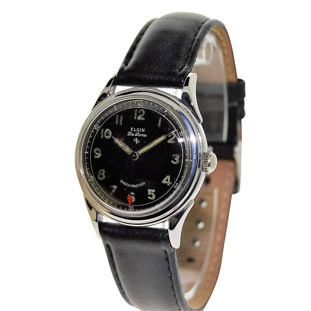 FACTORY / HOUSE: Elgin Watch Company
STYLE / REFERENCE: Round / Military Style
METAL / MATERIAL: Steel 
CIRCA: 1940's
DIMENSIONS: 41 mm X 33 mm
MOVEMENT / CALIBER: Manual Winding / 17 Jewels 
DIAL / HANDS: Black Arabic Luminous Numerals / Luminous