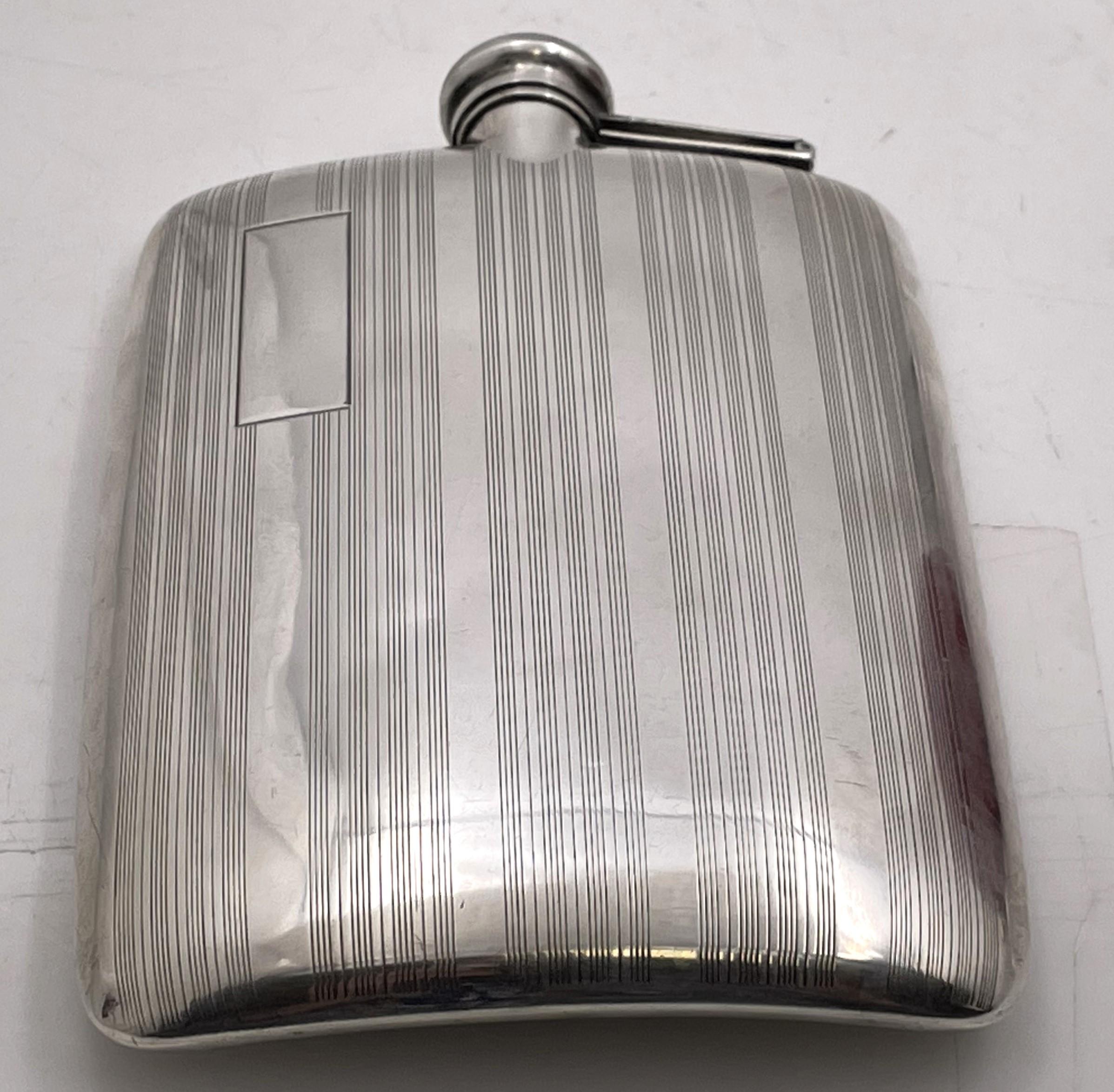 Elgin sterling silver flask, beautifully engraved, in Art Deco style and from the early 20th century. It measures 5 5/8'' by 3 7/8'' by 3/4'', weighs 5.9 troy ounces (183.5 grams), and bears hallmarks as shown. 

The Elgin American Manufacturing