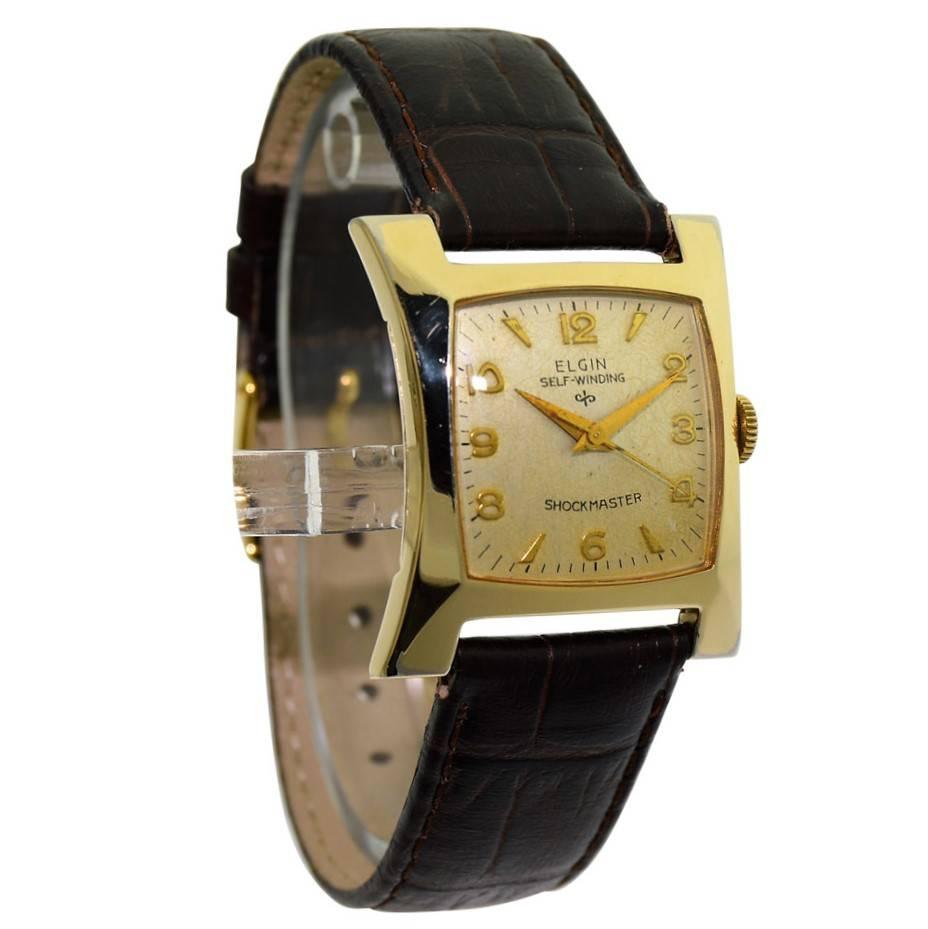 FACTORY / HOUSE: Elgin Watch Company
STYLE / REFERENCE: Art Deco / Hourglass
METAL / MATERIAL: Yellow Gold Filled
CIRCA: 1960's
DIMENSIONS: 34 mm X 29 mm
MOVEMENT / CALIBER: Automatic Winding / 17 Jewels 
DIAL / HANDS: Original Silvered Arabic and