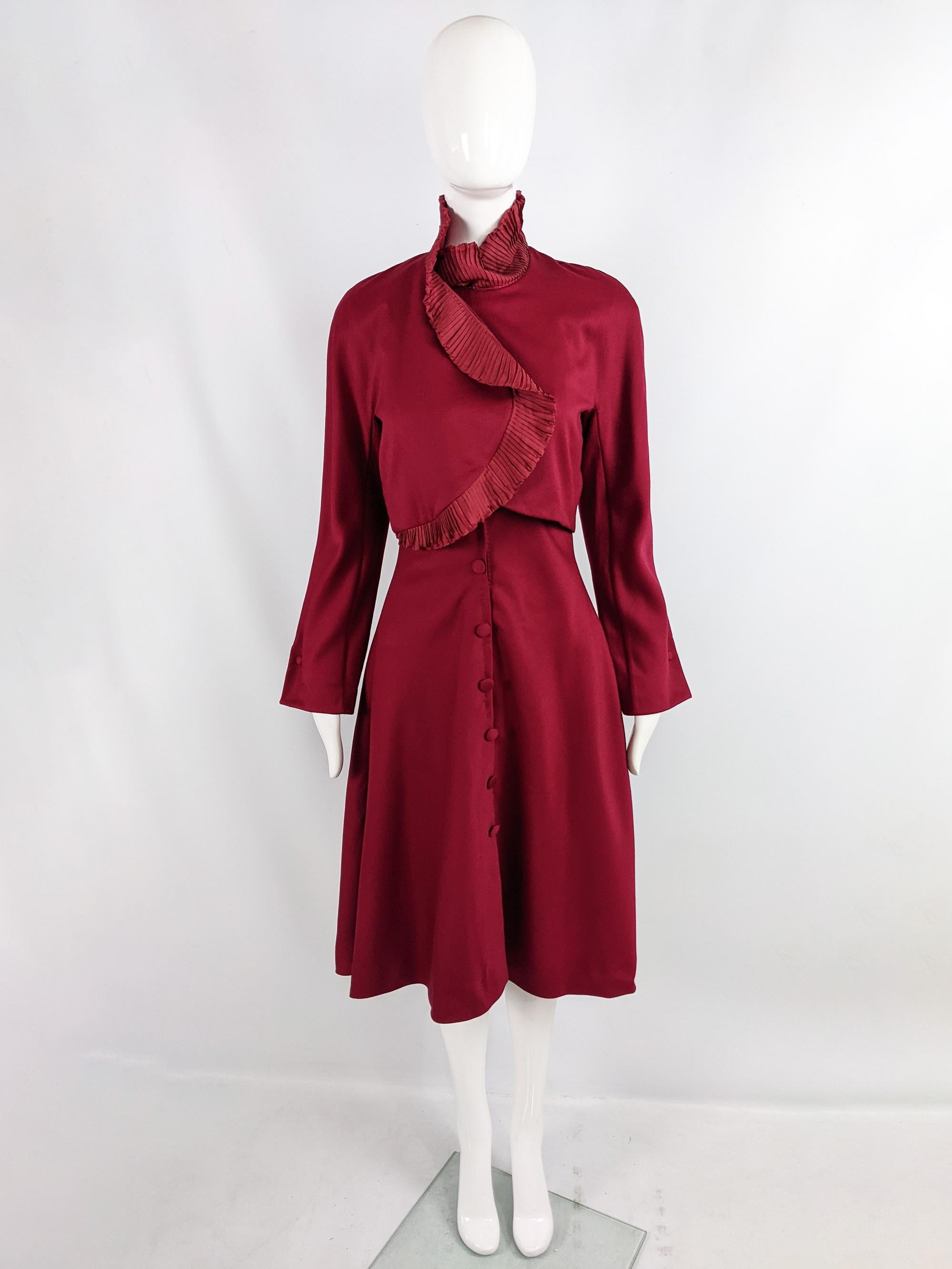 An incredible vintage womens dress from the 80s by luxury Italian fashion designer, Eli Colaj. Incredibly constructed, in a wine red wool with a sleevless silk taffeta underdress with attached shoulder pads and an attached long sleeve jacket with a
