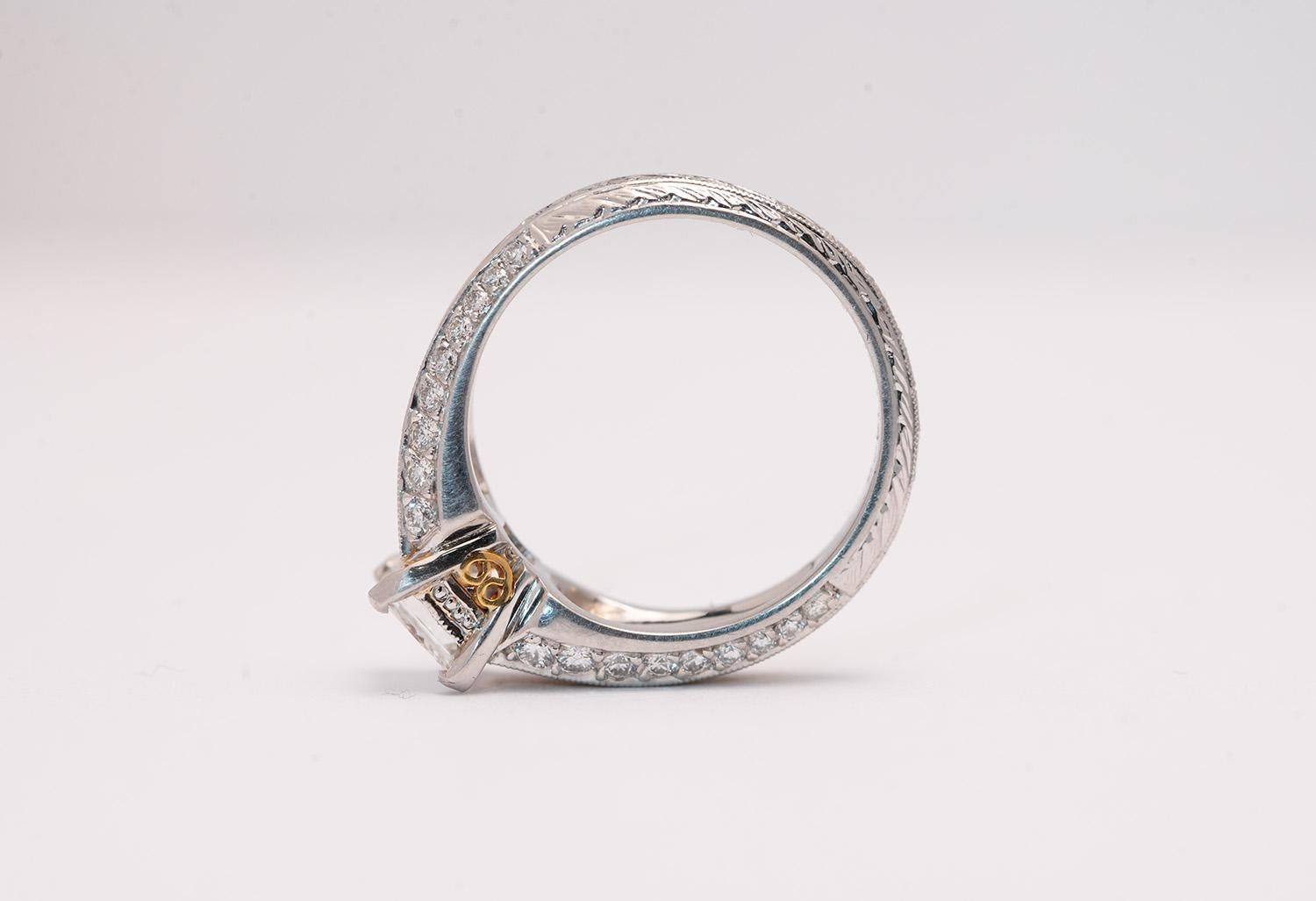 Natural 1.01 carat radiant cut diamond center  estimated J color VVS2 clarity set in an Eli Jewels two tone platinum and gold designer mounting.

A masterful blend of noble metals and elegant design, this engagement ring by Eli Jewels showcases