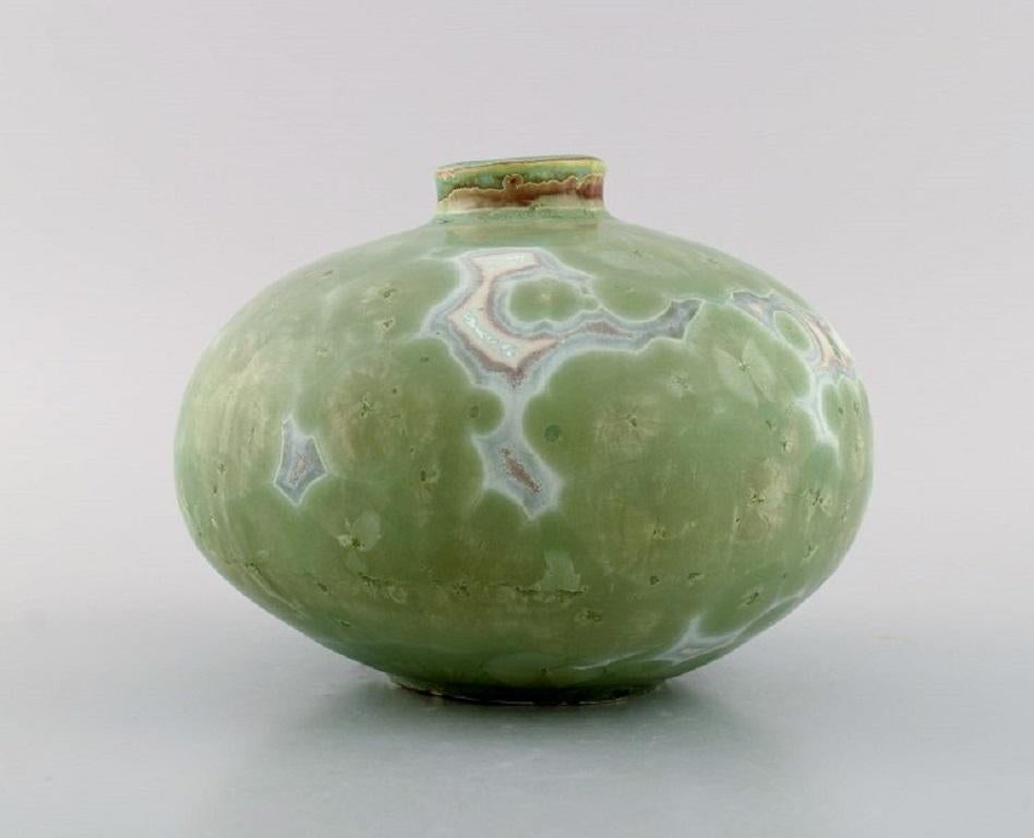 Eli Keller (b. 1942), Sweden. Round unique vase in glazed stoneware. 
Beautiful crystal glaze in light green shades. 21st Century.
Measures: 17 x 12.5 cm.
In excellent condition.
Signed.