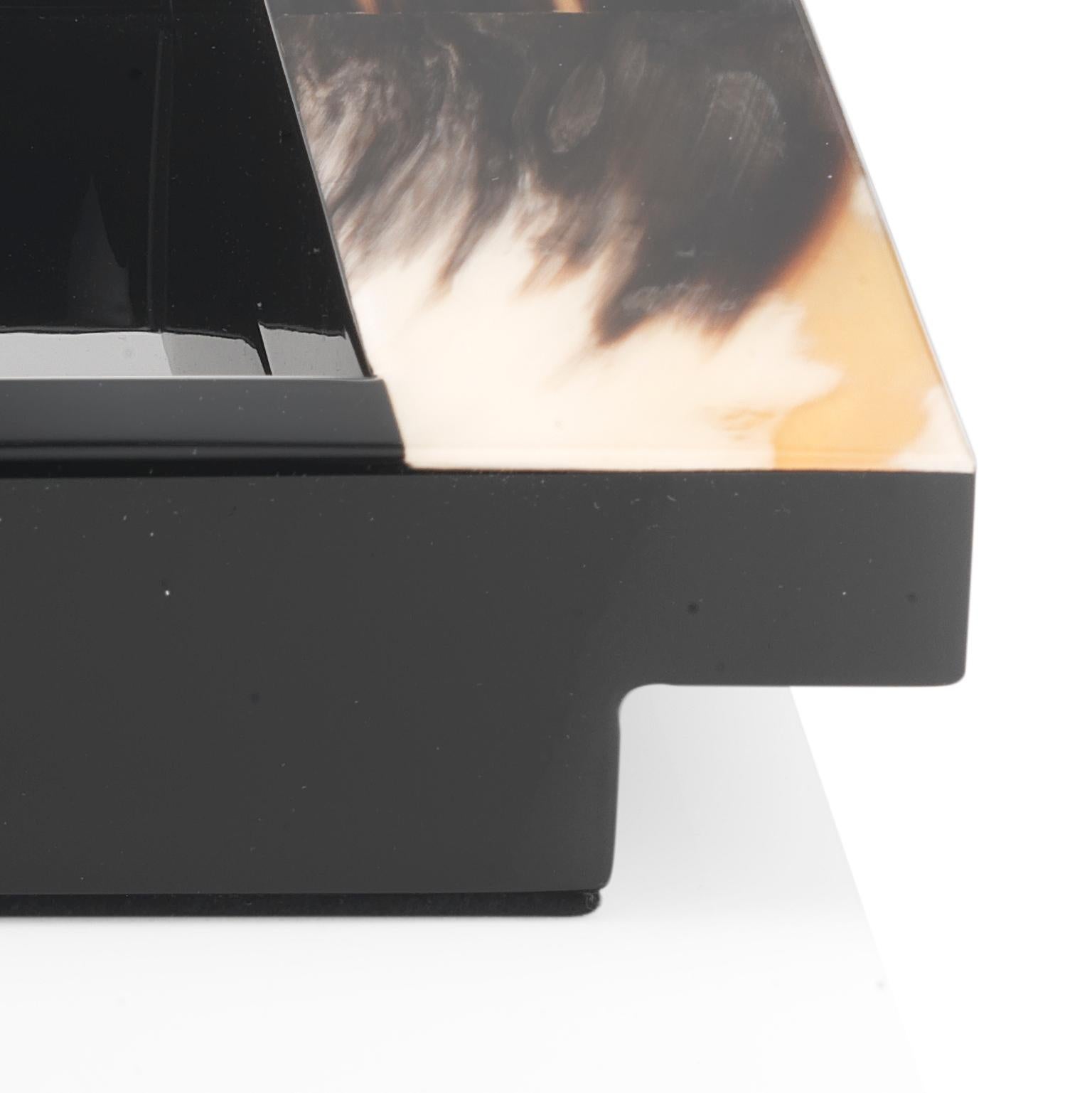 L'artisanat exquis et les matériaux nobles font du plateau Elia un ajout sophistiqué à tout décor exigeant. Doté d'une structure rectangulaire en bois laqué noir brillant, le design se distingue par d'élégantes poignées en Corno Italiano, ajoutant