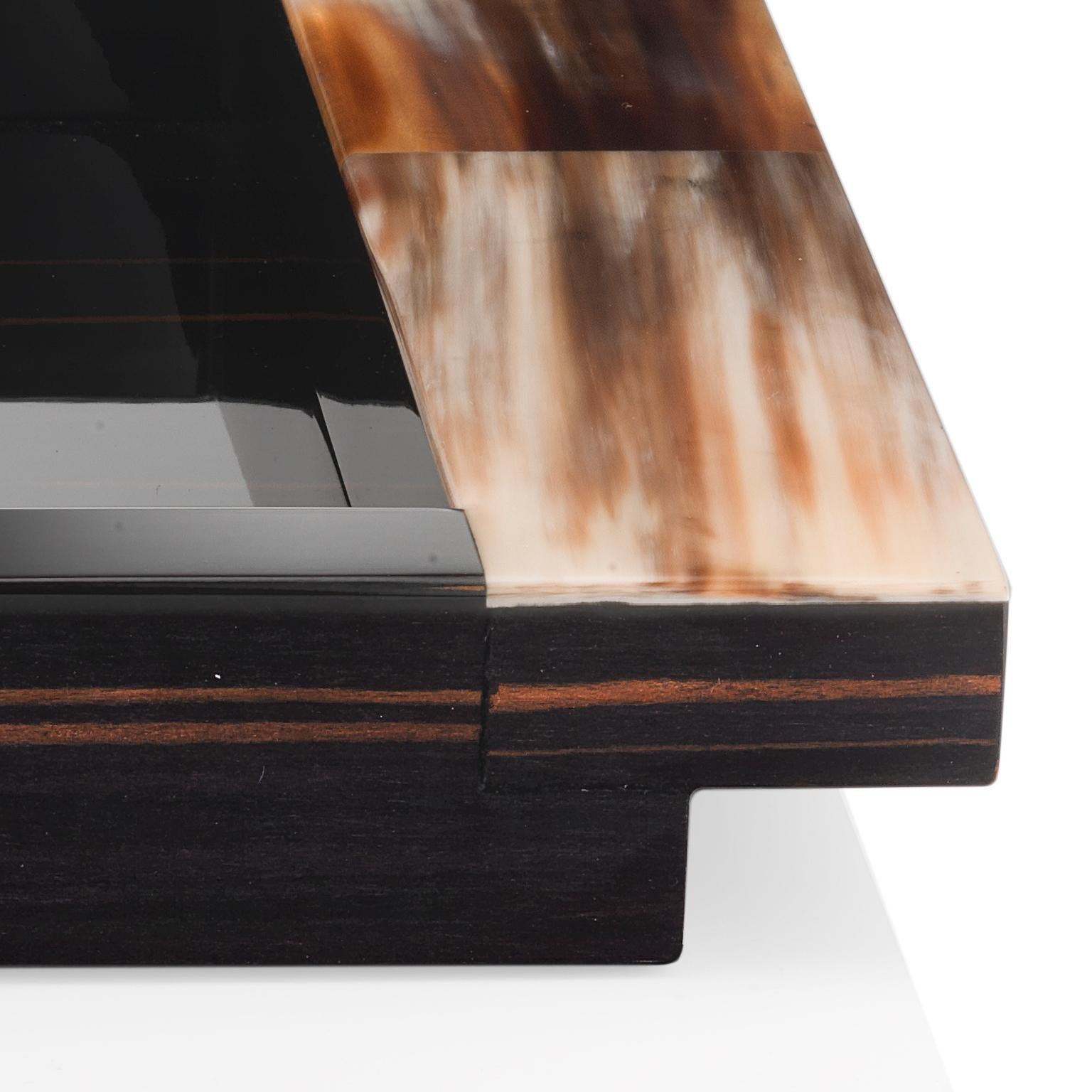 Exquisite craftsmanship and fine materials make Elia tray a sophisticated addition to any demanding decor. Featuring a rectangular wooden structure in glossy ebony, the design is distinguished by elegant handles in Corno Italiano adding a striking